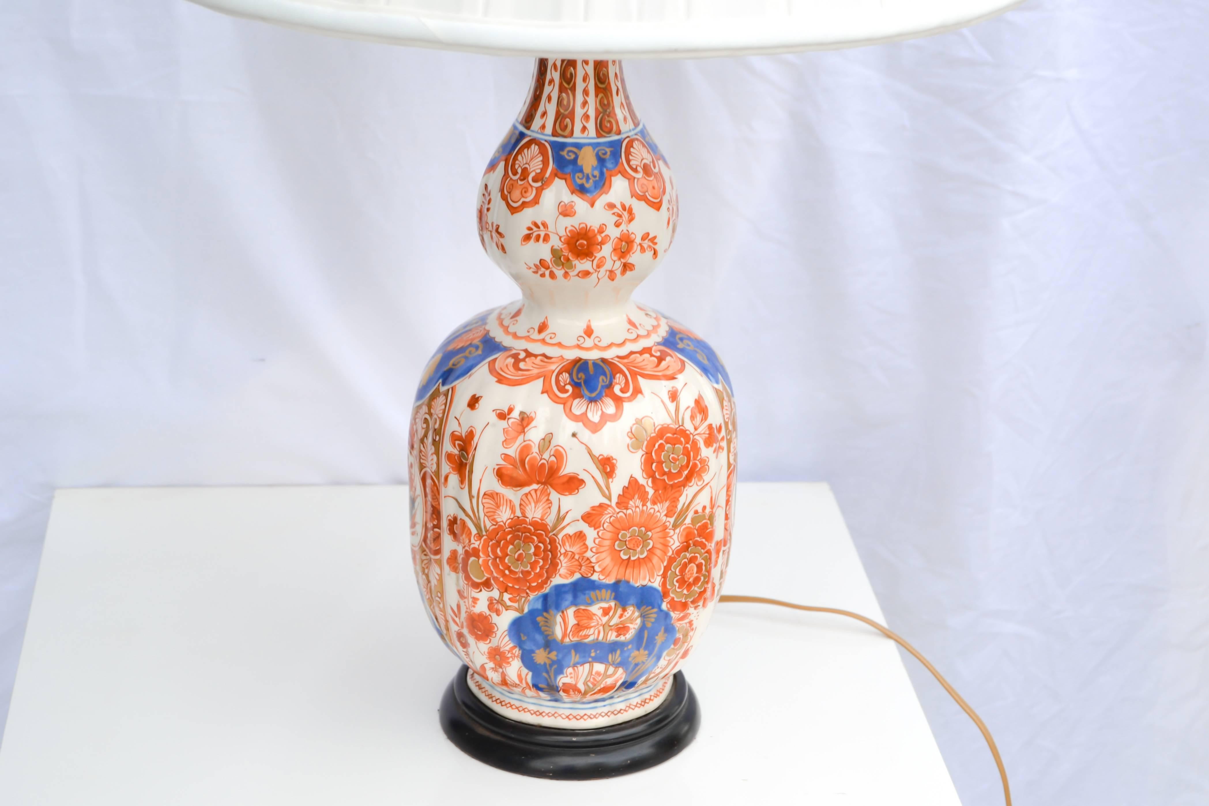 Delft style lamp in the Imari taste, double gourd form ribbed body mounted on ebonized wood baes. Rewired.