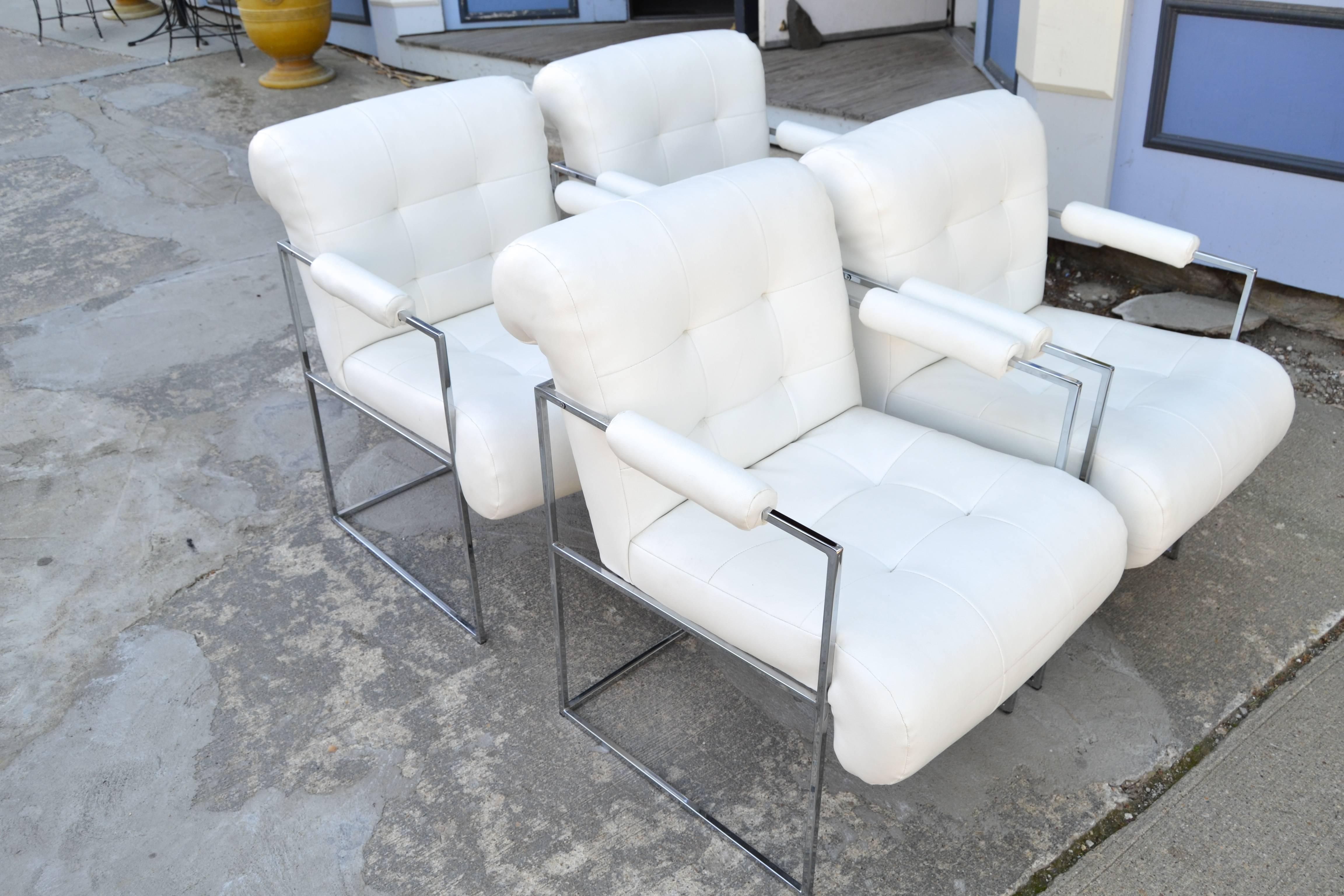 Four white Naugahyde chrome arm chairs by Milo Baughman for Thayer Coggin.
Biscuit tufted and extremely comfortable, these Mid-Century dining chairs have a rolled back and padded arm rests. The chairs are also great as occasional chairs.