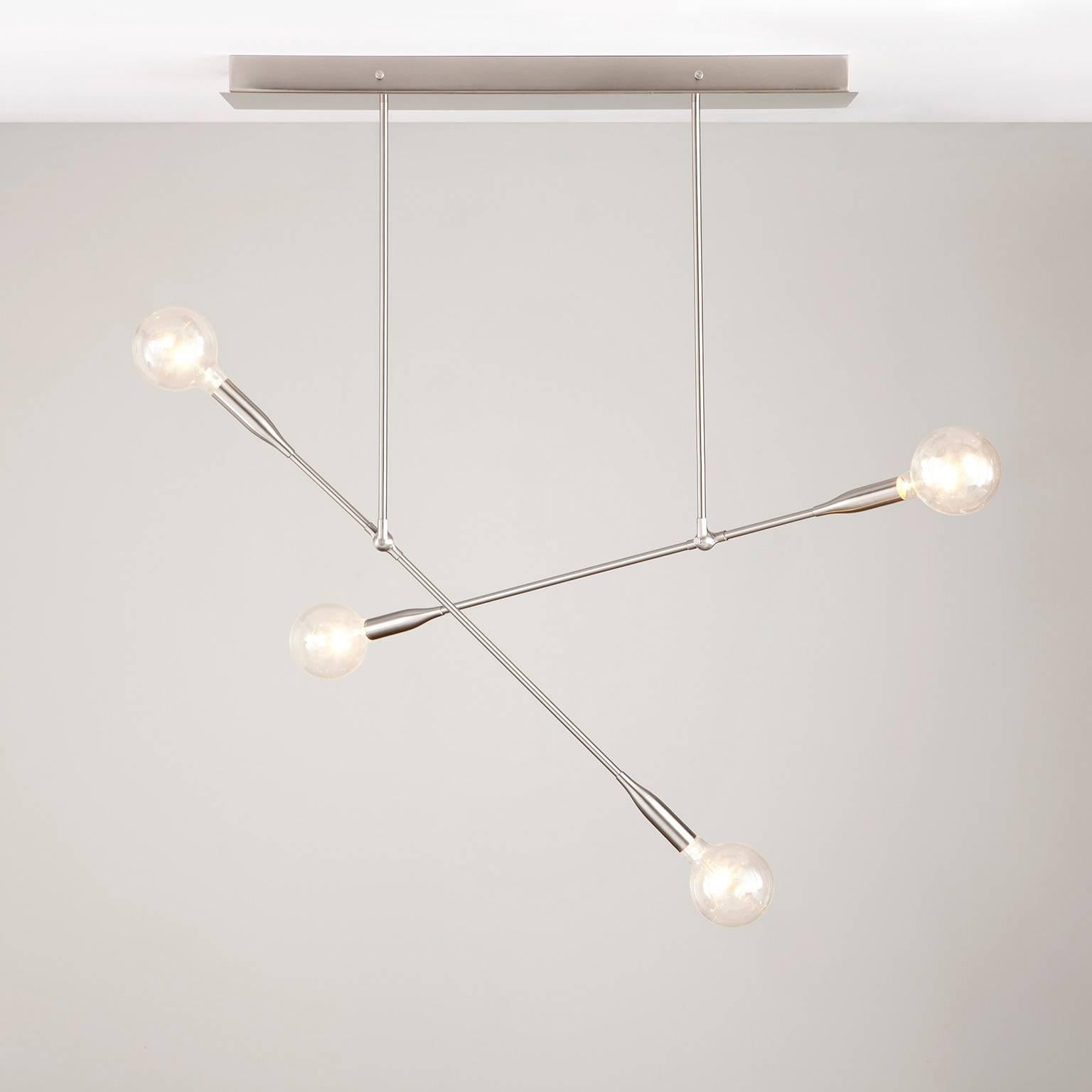 Two Sorenthia Lights create dramatic angles on a handcrafted rectangular ceiling canopy. This midcentury-inspired, statement chandelier features exposed bulbs, bold lines, and dramatic negative space. The elegant, reaching arms of each drop can be