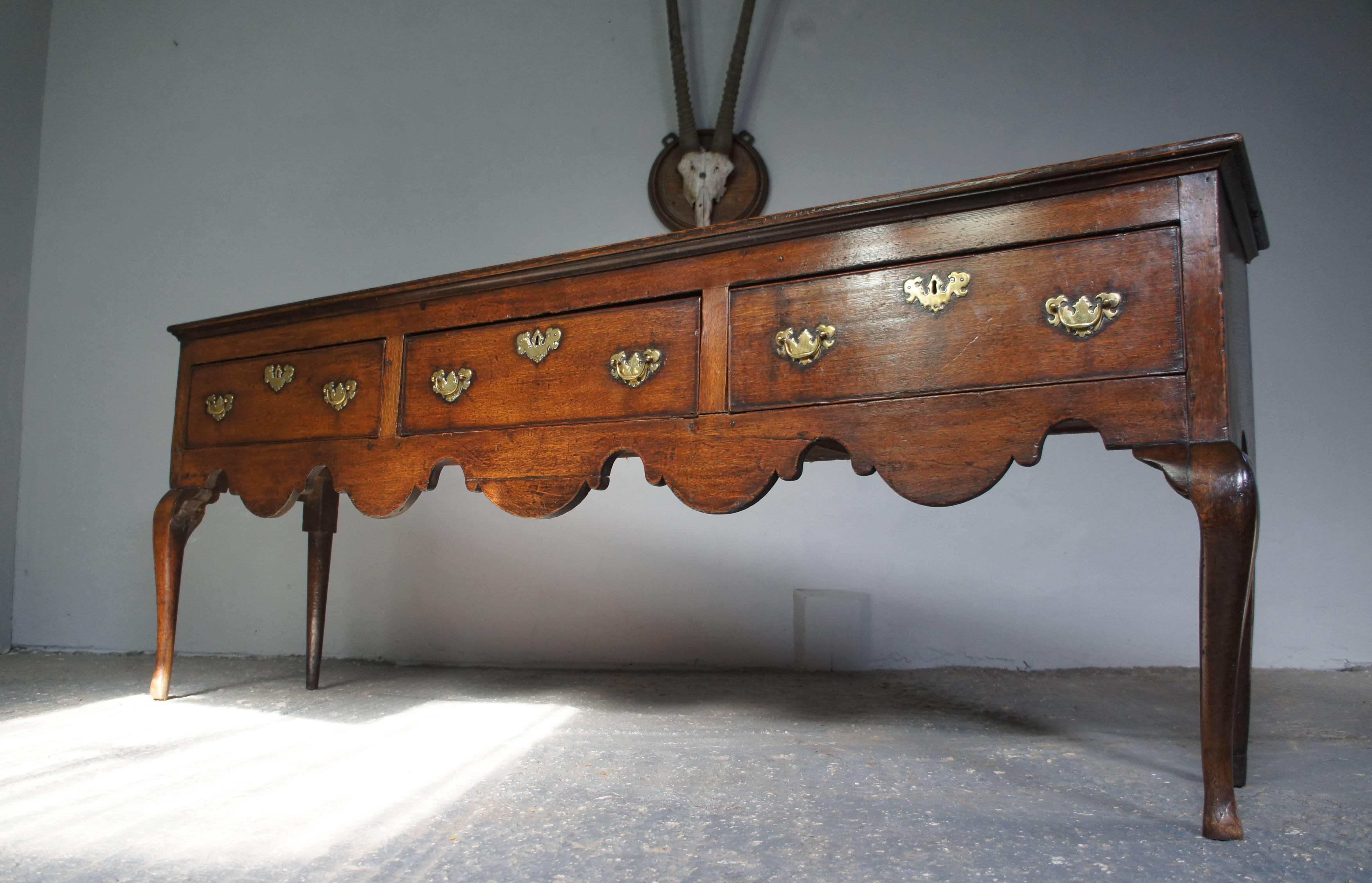 Stunning Georgian oak dresser featuring a scalloped apron and cabriole legs to the front. The three drawers have brass handles and escutcheons. All drawers run smoothly.
The perfect piece to complement any home.