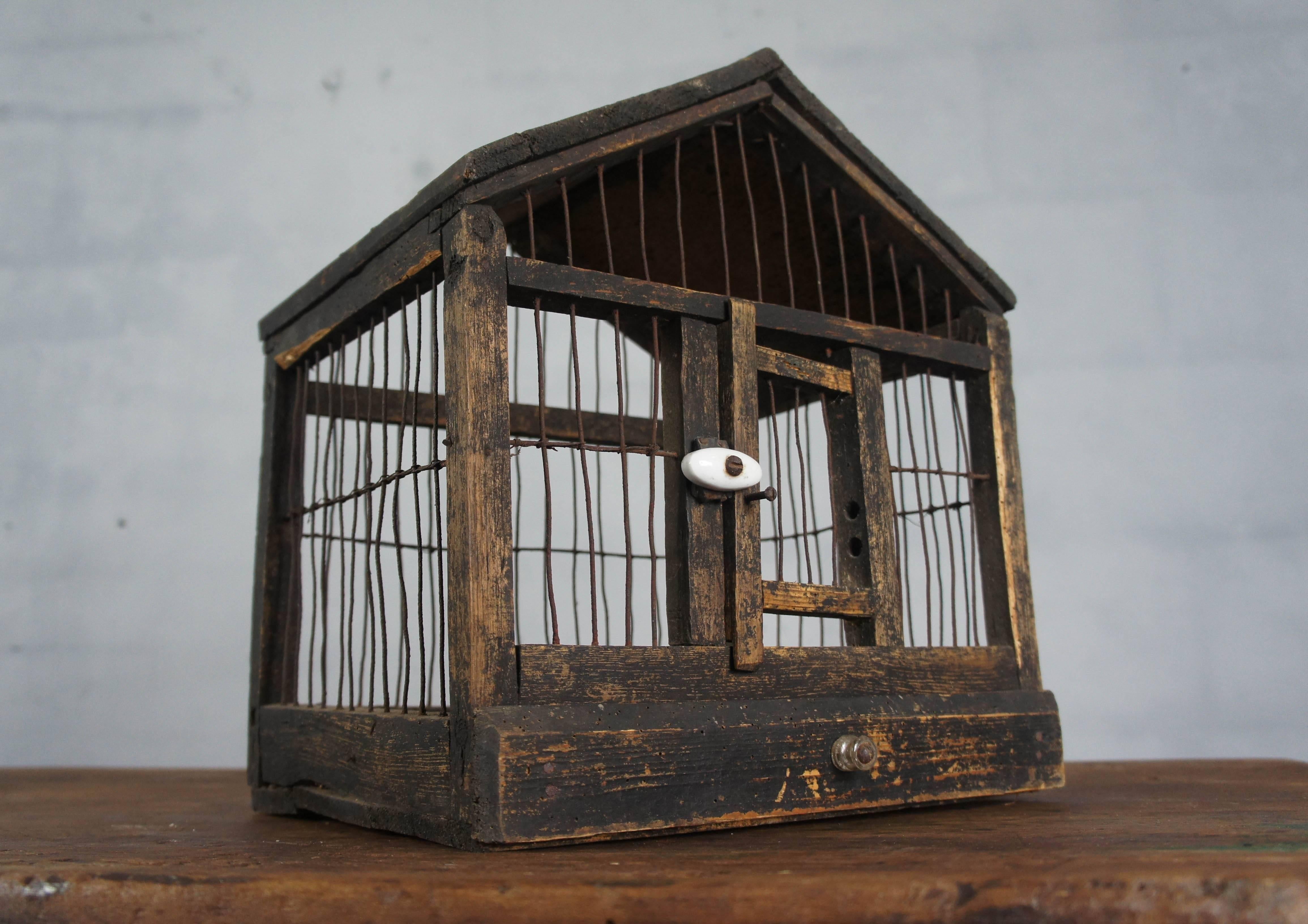 Provincial French indoor birdcage. Primitive wooden and wired detail with Fine porcelain handle. Often used to house songbirds this piece takes us back to an era where pleasure was found in simple things.