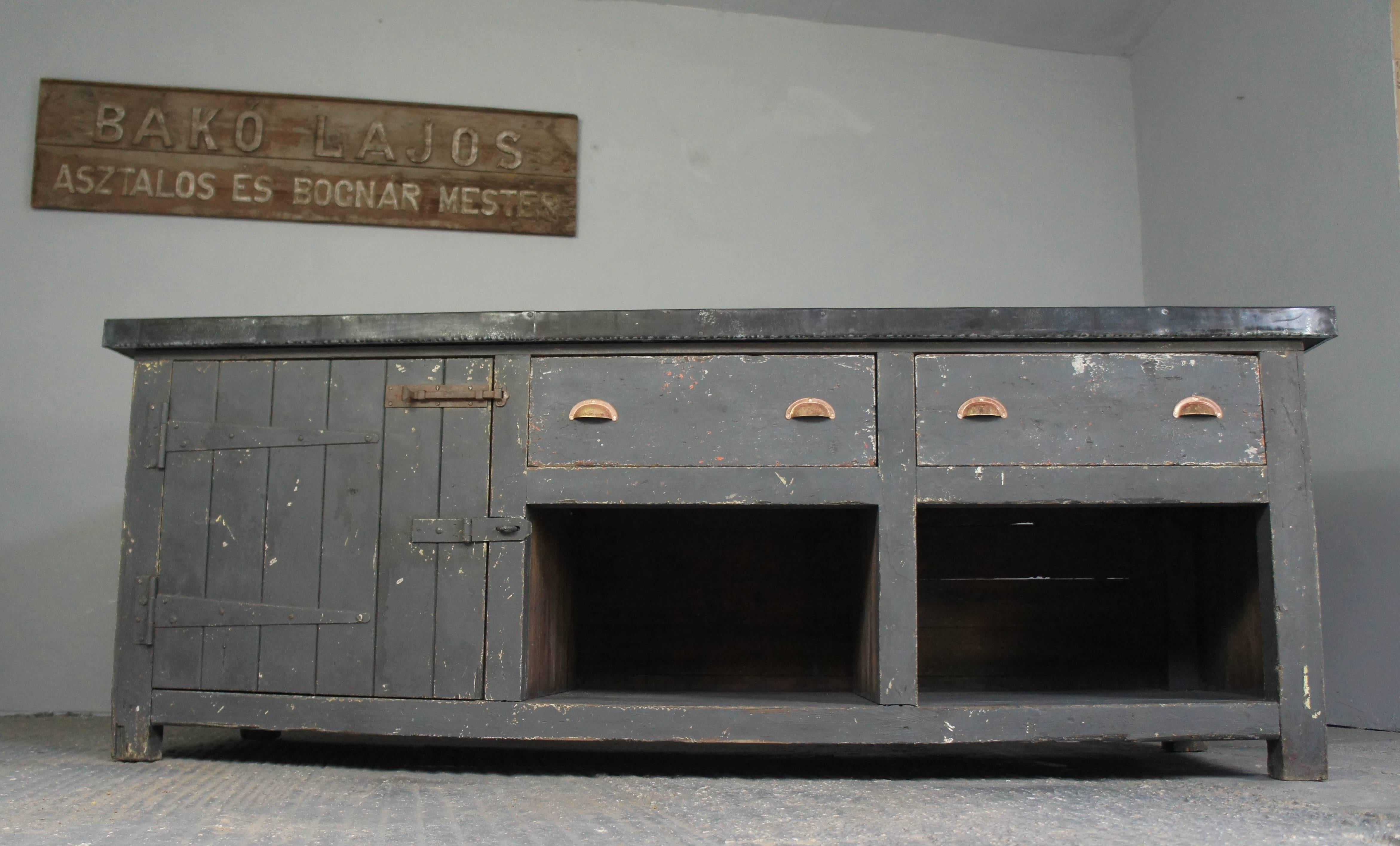 A unique piece of vintage Industrial furniture finished off with an aged zinc top. There is ample storage provided by a cupboard to the left and two large drawers over open shelves to the middle and right hand side.
Perfect as a sideboard in the