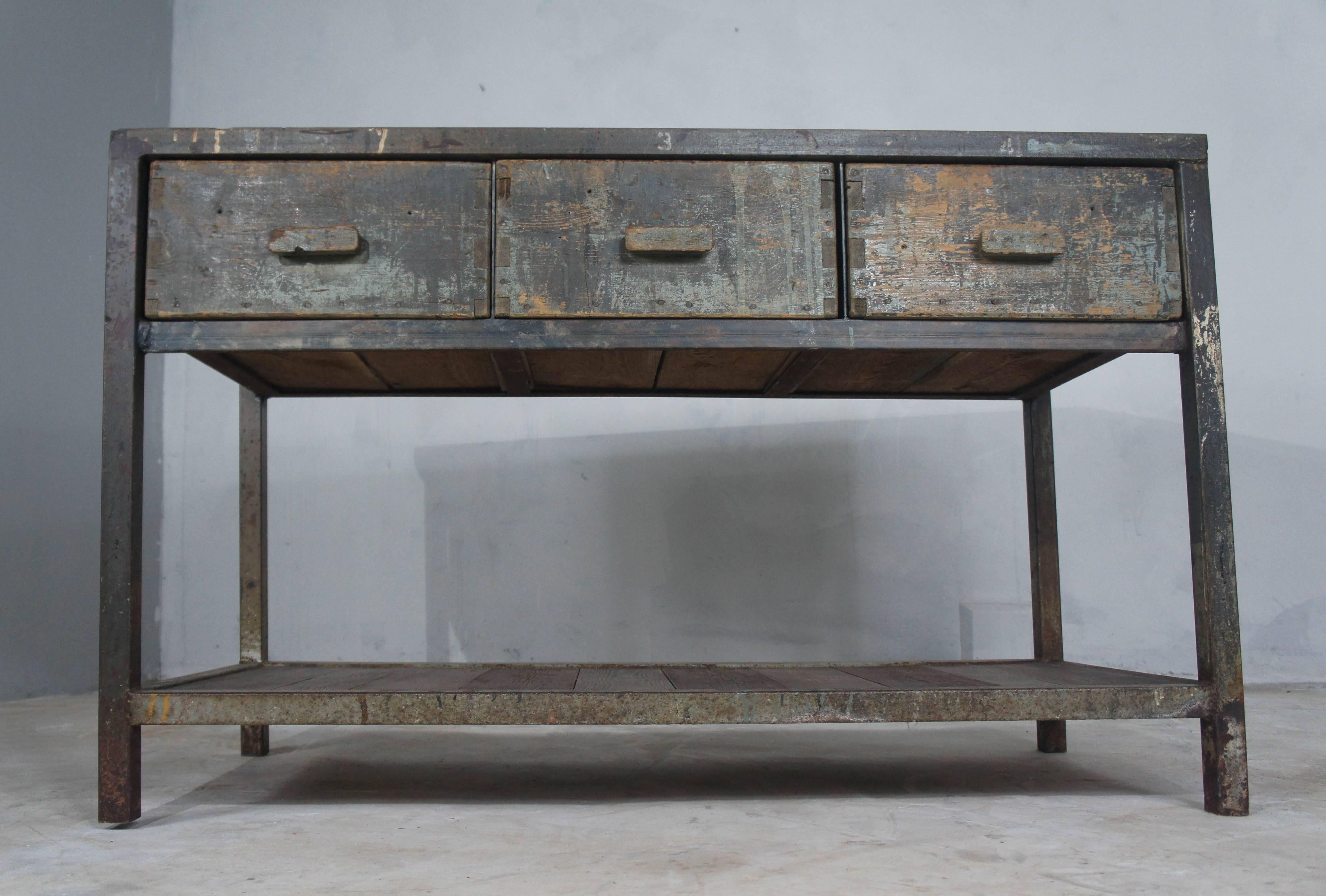 This three drawer steel framed workbench has been repurposed to make a fantastic industrial kitchen island. We have added a dark grey cement resin top which complements the existing frame and style of the piece. The concrete looking top overhangs