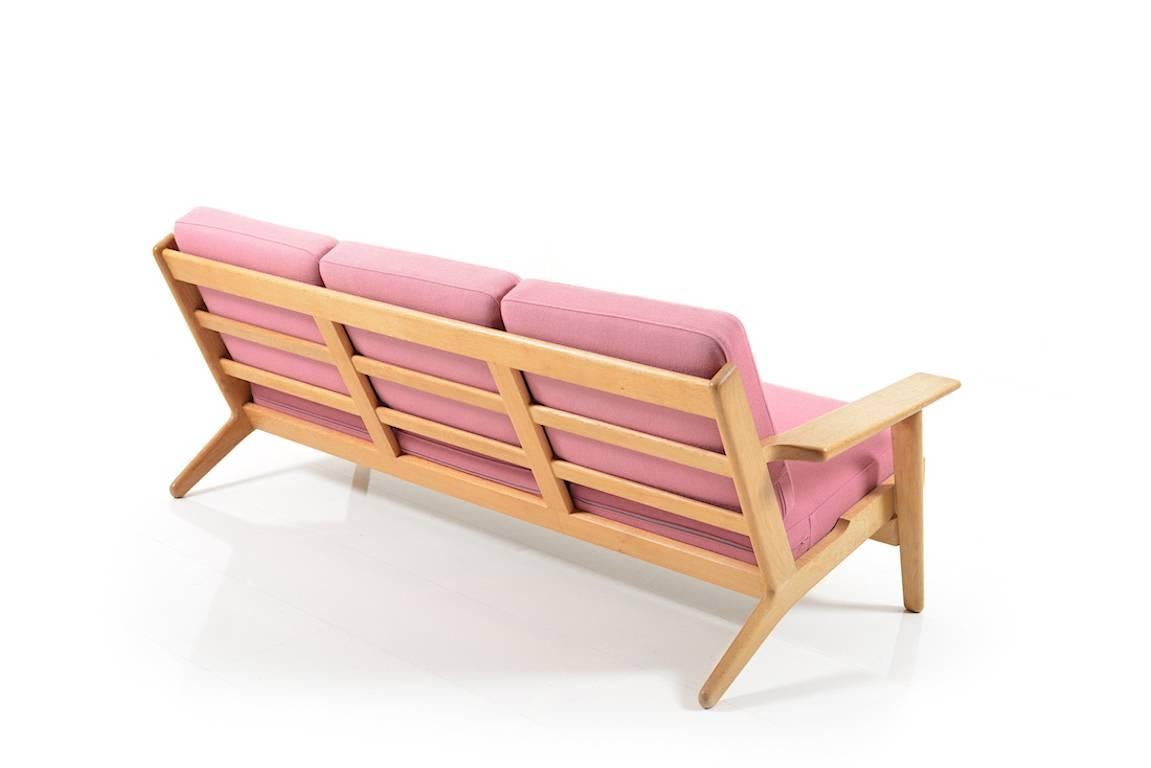 Three-seat in solid oak. Model GE-290/3 by Hans J.Wegner. Manufactured by GETAMA. Original cushions in rose fabric.

Note: please see the matching lounge chairs.