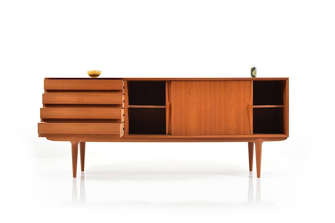 High quality teak wooden sideboard. Model 18. Designed in 1961 by Gunni Omann & made by Omann Jr. Møbelfabrik, Denmark. Front with two sliding doors and four drawers. Behind the doors with a shelf. Fine Danish vintage quality.