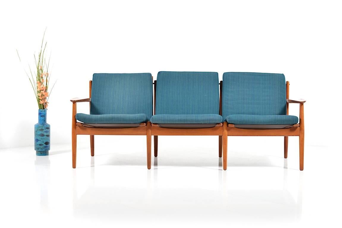 Early three-seat sofa in teak. Designed by Grete Jalk (born in Denmark 1920). Manufacture by Glostrup. Original cushions with blue/turquise fabric.