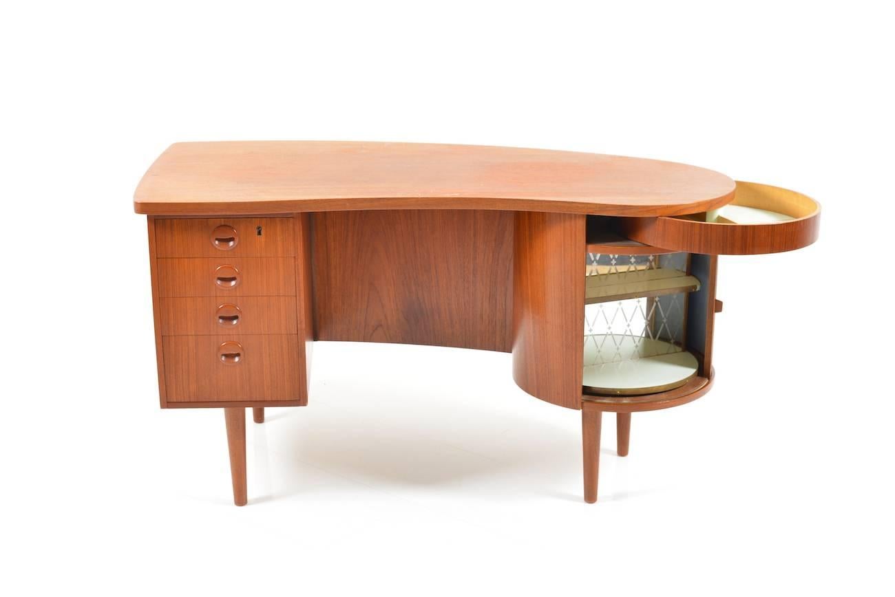 Freestanding kidney / organic desk in teak with home bar and hidden drawer. Model 54. Designed 1956 by Kai Kristiansen for FM Furniture, Feldballe Denmark.