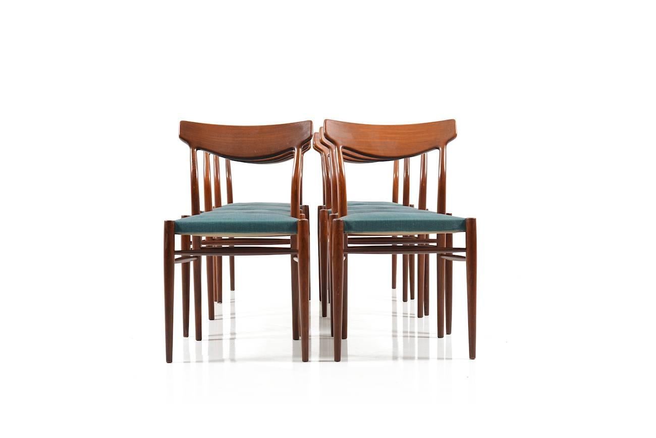 Set of eight solid teak wooden dining chairs by Lübke (Luebke). Produced in 1960s. Seats in original mint-green fabric. Wood in very good condition. Seats/fabric with use of trace.