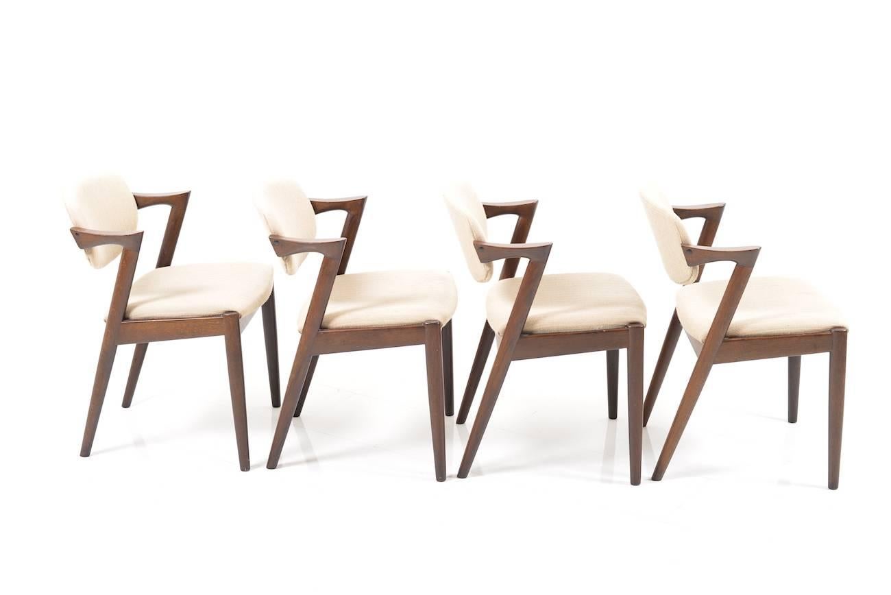 Set of four Kai Kristiansen dining chairs in solid dark oak. Model 42, 1960s. Original cream/grey fabric from Kvadrat, Denmark.