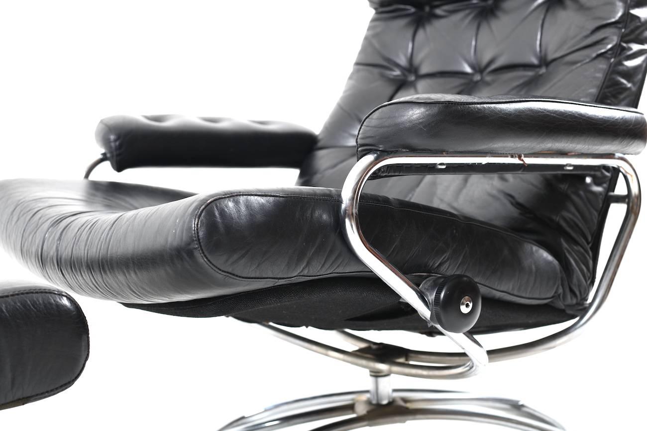 Midcentury lounge chair and ottoman by Ekornes. Upholstered in original black leather.