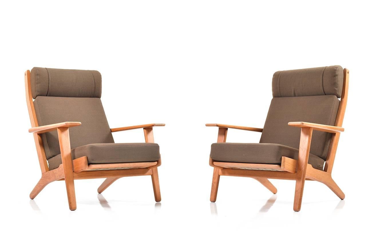 Pair of high back lounge chairs in solid teak. Model GE-290 by Hans J. Wegner. Manufactured by GETAMA. Original cushions in brown wool fabric. Possible to buy separately one chair.