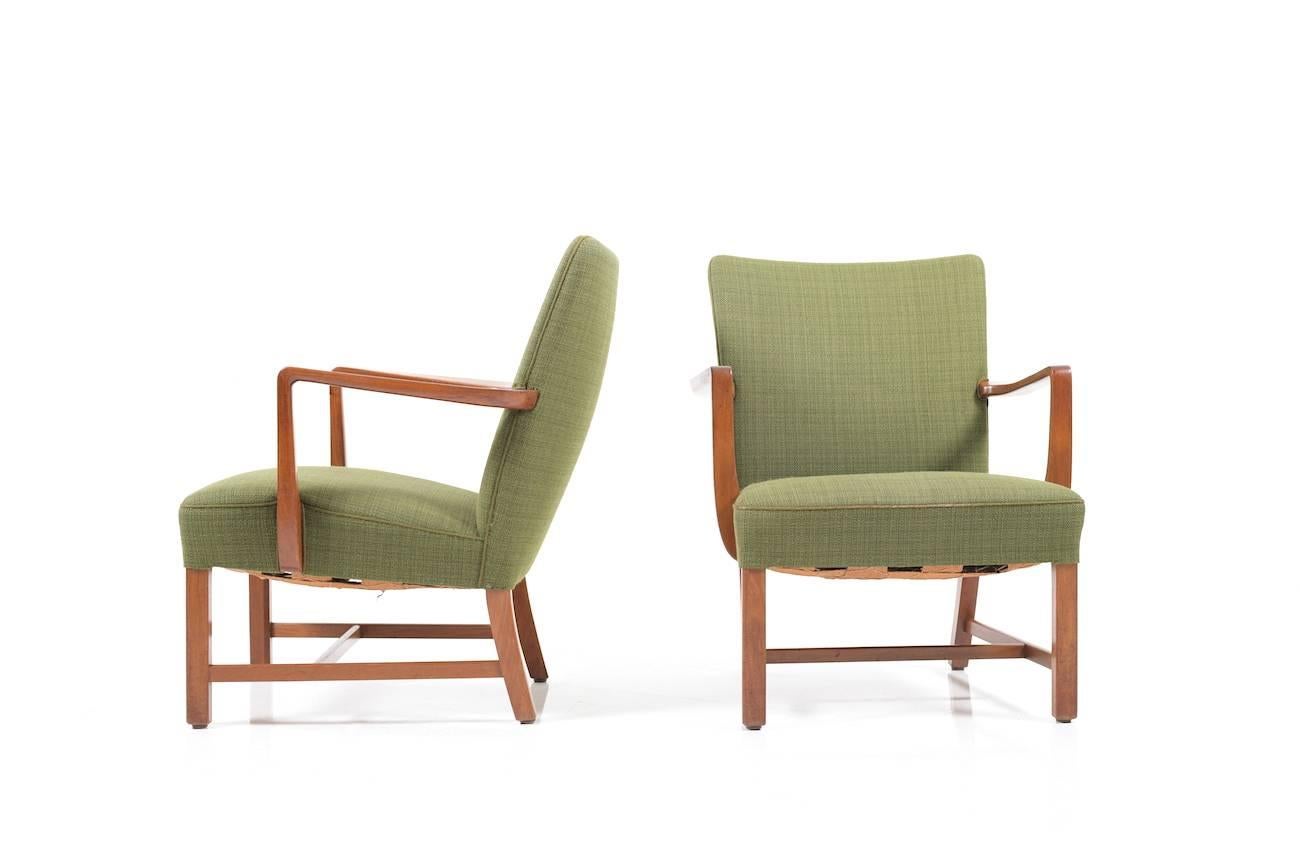 Set of beautiful early Danish lounge chairs. Probably by Jacob Kjaer. Manufactured 1930s or 1940s. Base armrests in solid teak. Original green fabric. Chairs are in good original stand.