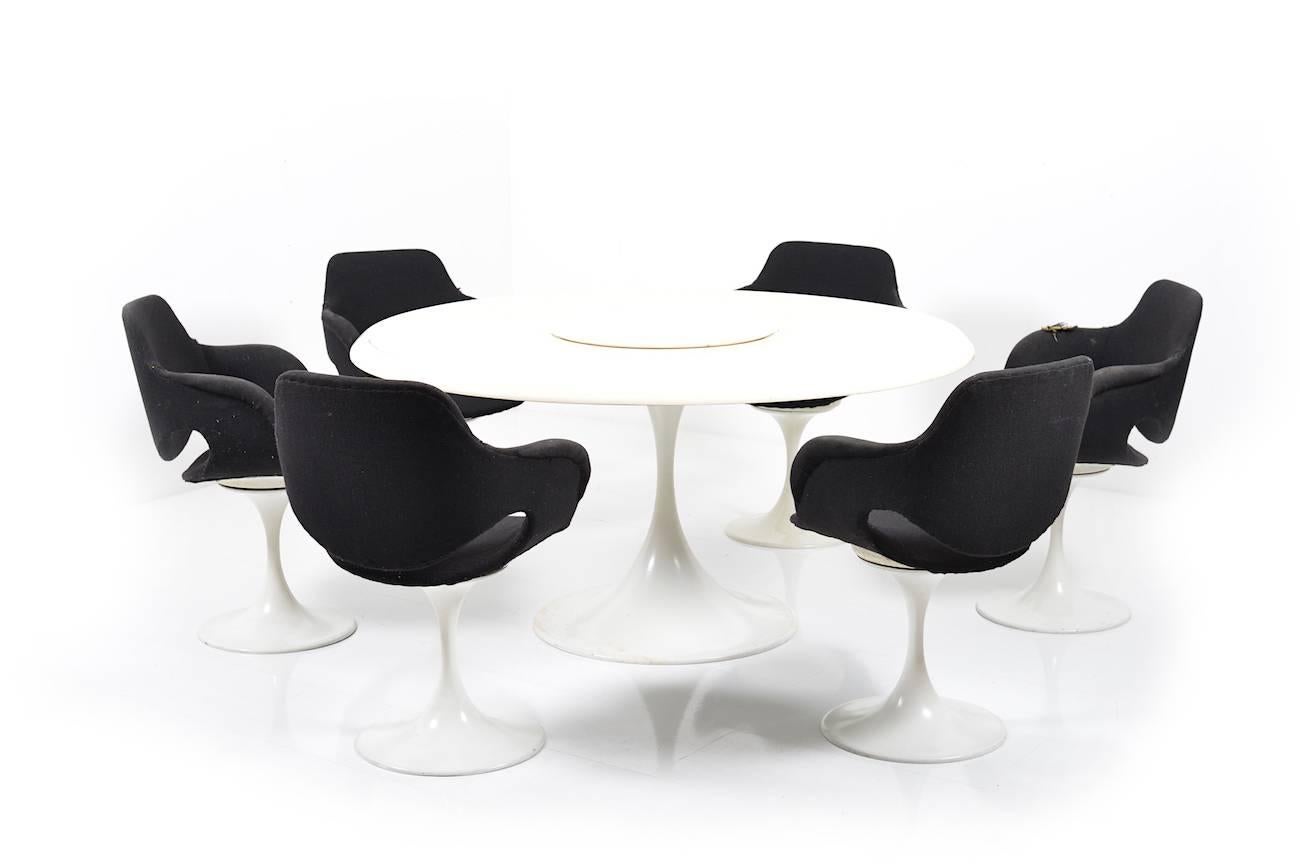A rare Scandinavian late 1960s dining-set. Tulip-shaped seating group consisting of six armchairs and a big round table. In the middle of the table a rotatable disc. White laquered metal, seats in original black fabric. Scandinavian/Denmark late