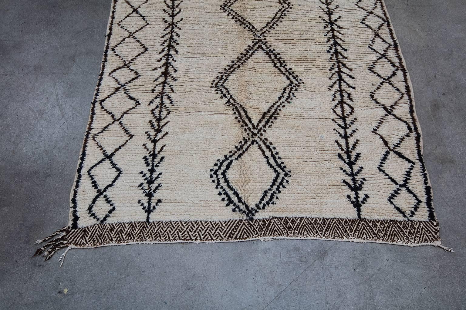 This rug hails from the Aït Bouguemez tribe in the Atlas Mountain region of Azilal. The defining Aït Bouguemez trademark of this piece are the flat woven bands at either end of the carpet. Azilal rugs are known for their artistic, abstract and