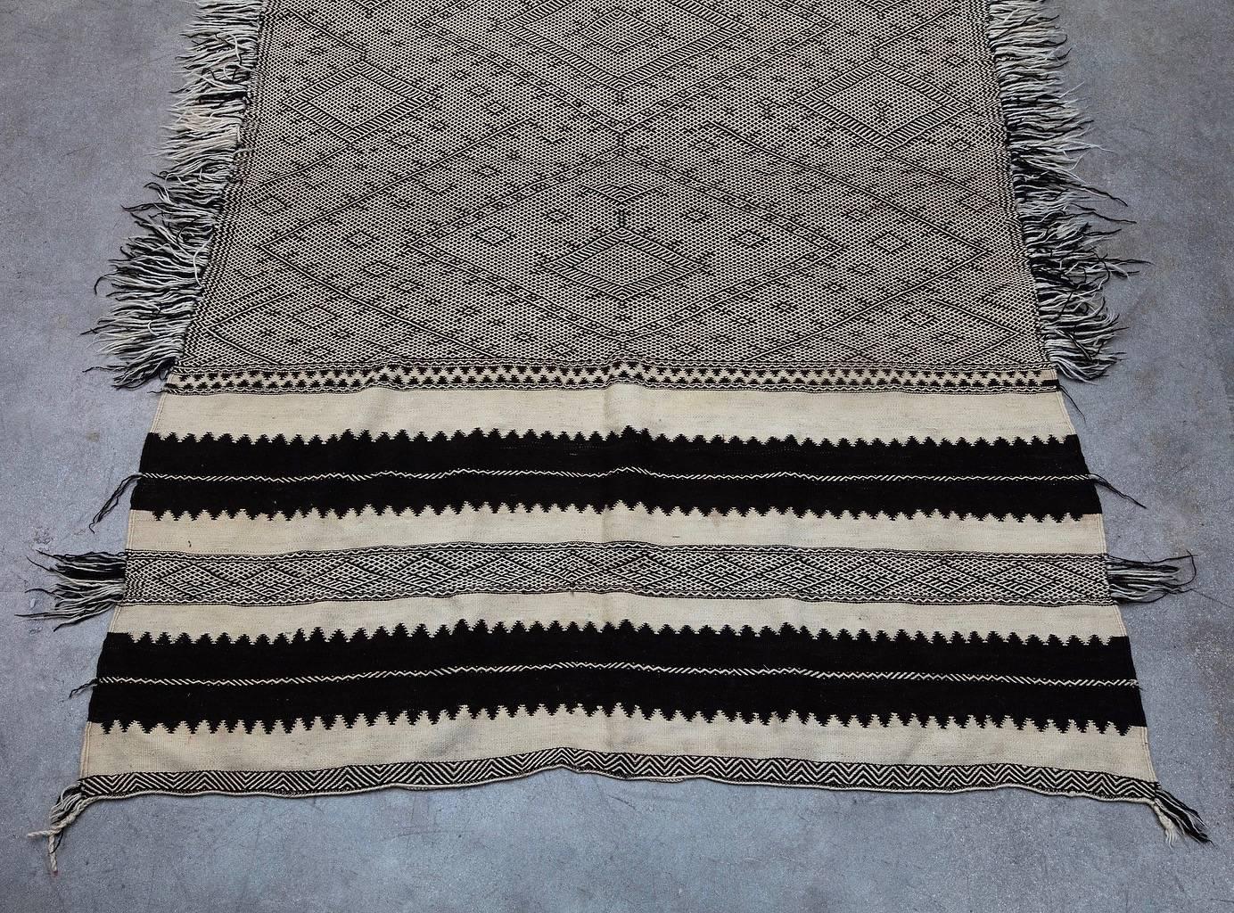 This piece is a rare and older style type of Zanafi rug. Handwoven by Berber tribes who reside in the the High Atlas Mountains in Morocco. Zanafi rugs are known by the special pattern which consist of different elements of zigzags, triangles,