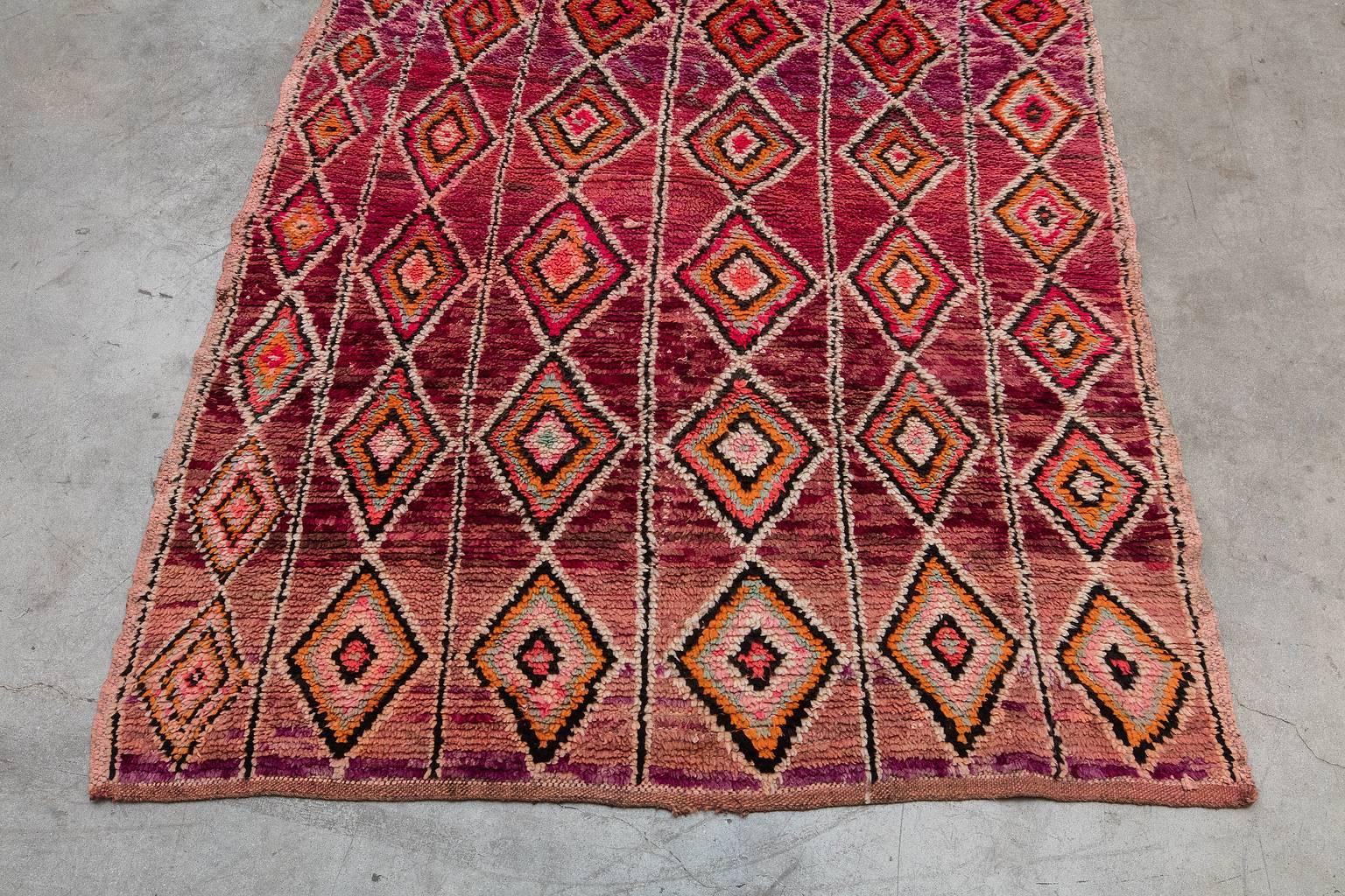 Originating from Khouribga in the Middle Atlas region of Morocco, Boujad rugs are low-pile and known for their abstract and geometric shapes. These artistic pieces are typically abundant in red, orange, pink and mauve colors.

Measurement does not