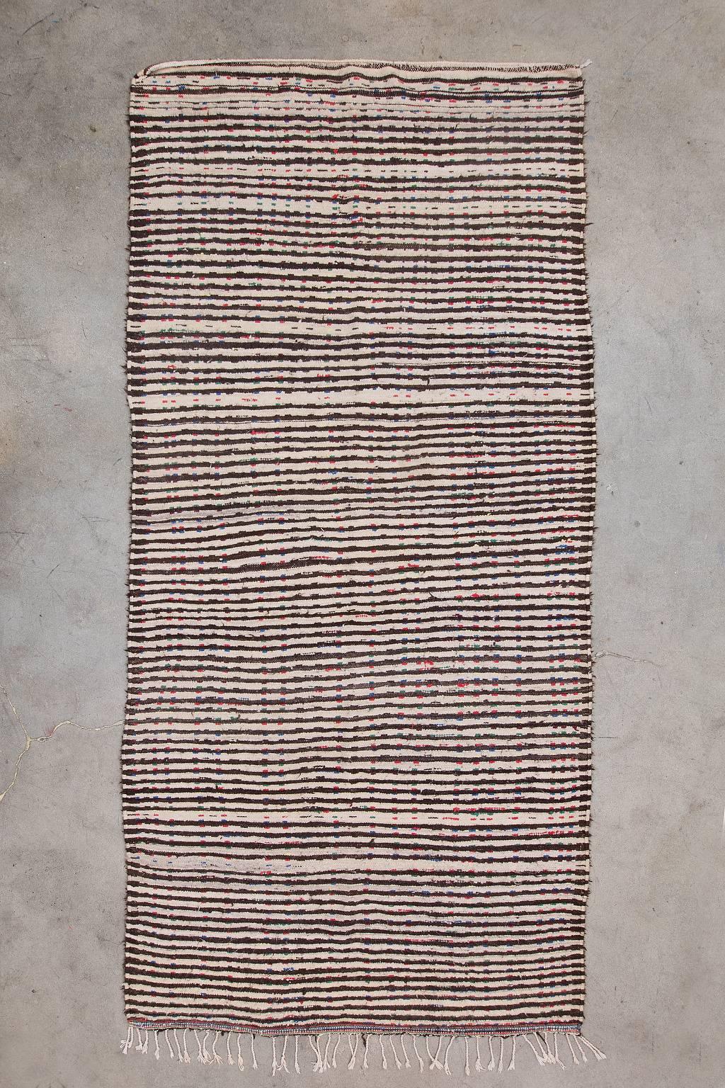 This stunning artistic piece is made by the Azilal Tribe in the High Atlas Mountains of Morocco. This pile rug is mixed with warm shaggy wool and cotton fibers. 

Measurement does not include fringe.