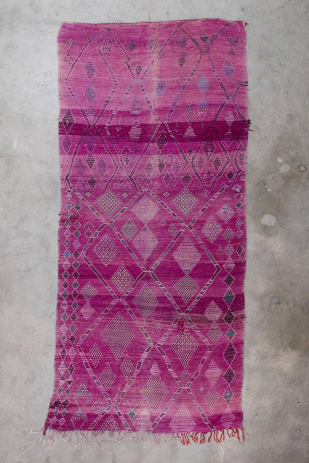 Originating from Khouribga in the Middle Atlas region of Morocco, Boujad rugs are low-pile and known for their abstract and geometric shapes. This artistic piece has a mauve base with abundant pink, black, green and blue diamonds.

Measurement