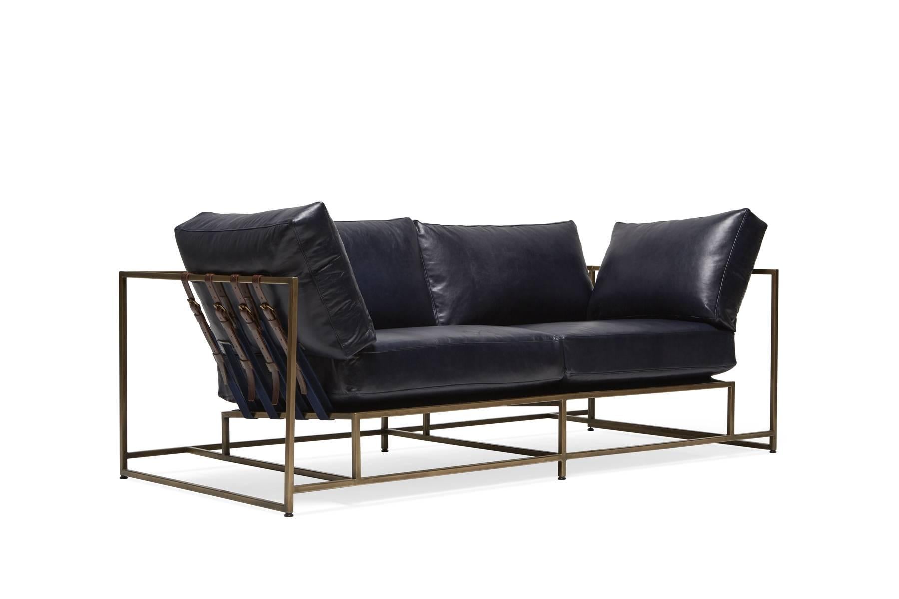 Diese neue Ergänzung unserer Zweisitzer-Sofa-Reihe hat einen weichen Indigo-Lederbezug, indigoblaues Baumwollgewebe und ochsenblutfarbene Ledergurte sowie einen Rahmen aus antikem Messing. Die Sitzkissen haben eine Daunenhülle über dem