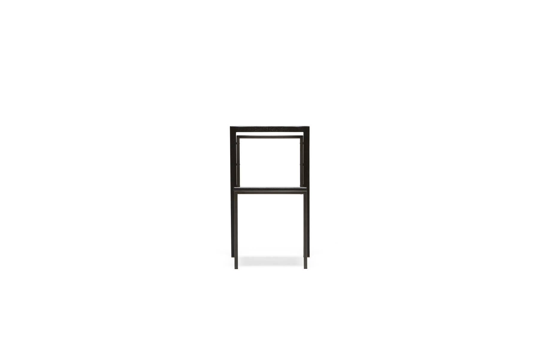 A solid oak and steel chair with a comfortable seat, easily stackable to save space when needed. This version has a blackened steel finished steel frame with an ebonized oakwood seat and backrest. Also available in this collection is an expandable