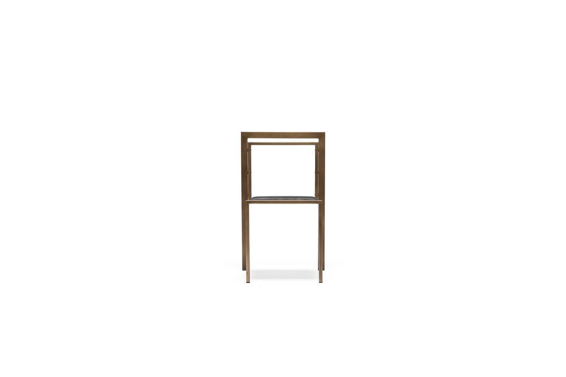 Una silla de acero y cuero con un cómodo asiento, fácilmente apilable para ahorrar espacio cuando sea necesario. Esta versión tiene un armazón de latón antiguo, un respaldo de latón antiguo y un asiento tapizado en cuero negro. Esta colección