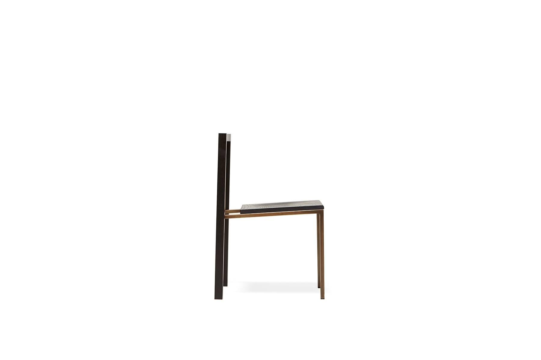 A solid oak and steel chair with a comfortable seat, easily stackable to save space when needed. This version has an antique brass finished steel frame with an ebonized oakwood seat and backrest. Also available in this collection is an expandable