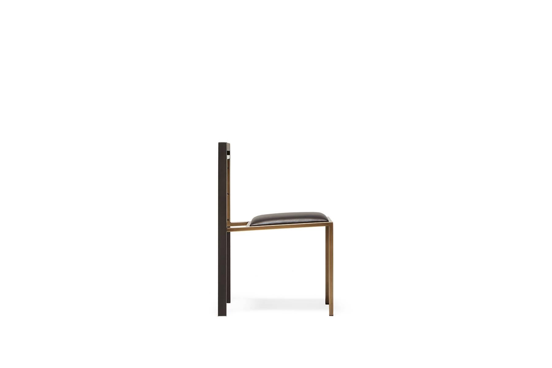 A steel and leather chair with a comfortable seat, easily stackable to save space when needed. This version has a steel frame with a brass finish, a blackened steel backrest, and a black leather upholstered seat. Also available in this collection is