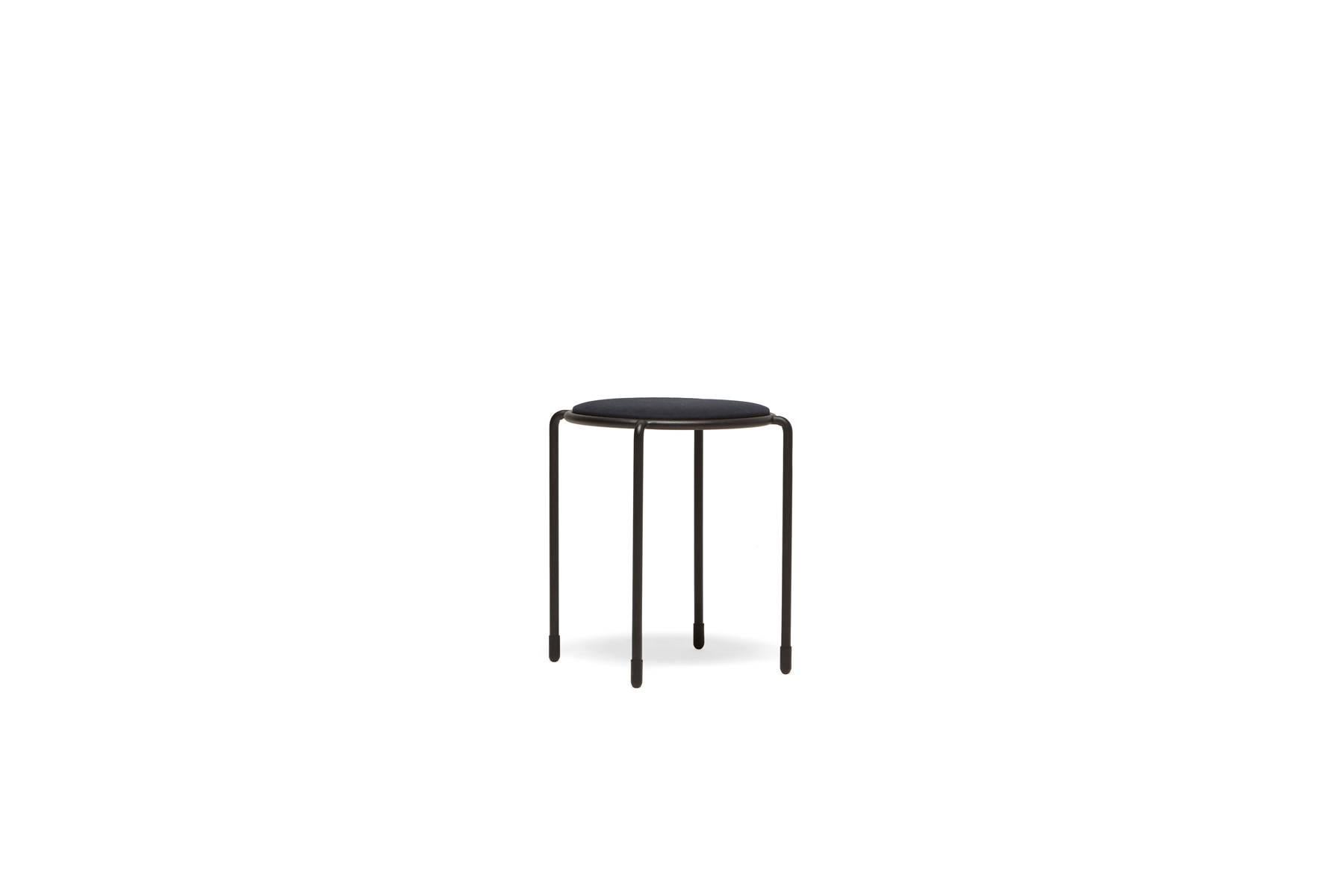 This stackable stool is upholstered in black canvas and paired with matte black steel legs.