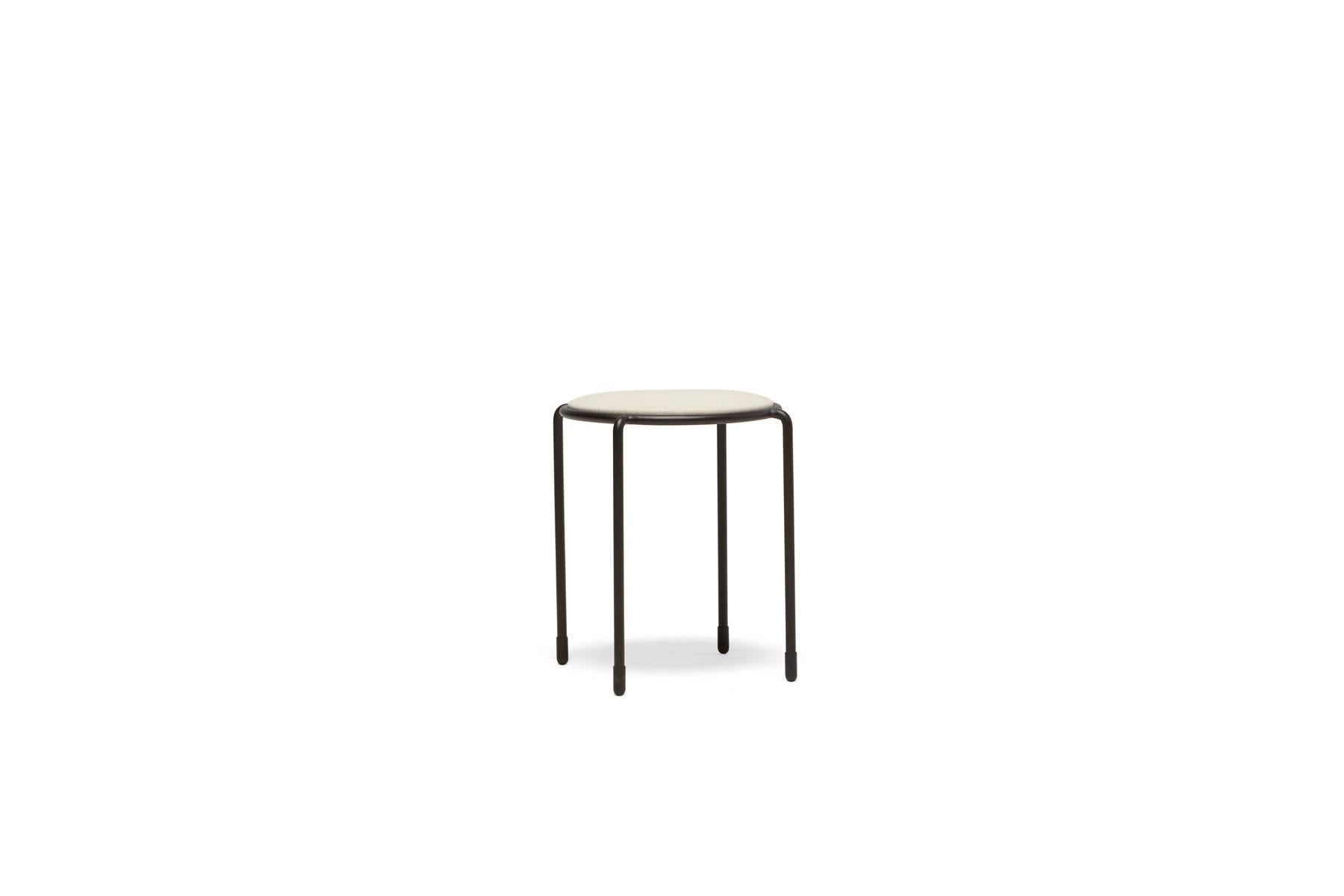 This stackable stool is upholstered in cream canvas and paired with matte black steel legs.