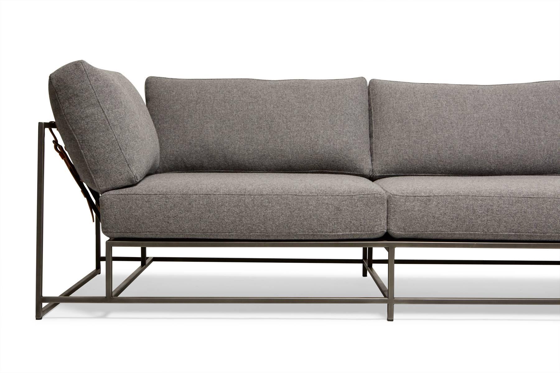 This sectional has an extra-wide chaise section to allow for the whole family to lounge together. Made in two pieces, leather cuffs are included to connect the frames together. Covers are made with soft grey wool upholstery, atop a blackened steel