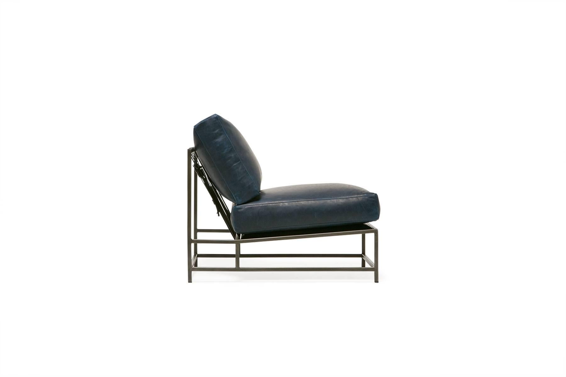 Sleek and refined, the Inheritance Chair is a great addition to nearly any space. 

This variation is upholstered in a rich navy leather. The foam seat cushions have been wrapped in down, allowing for a soft and comfortable lounge experience.