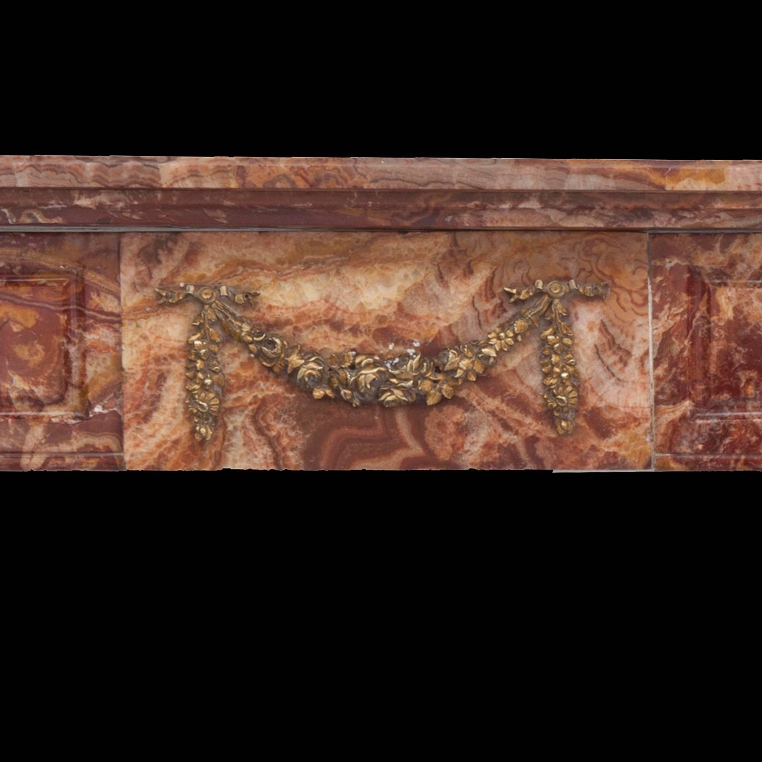 Antique Louis Philippe Rouge marble fireplace mantel.
Hand-carved with brass flutes, swags and rosette embellishments.
 