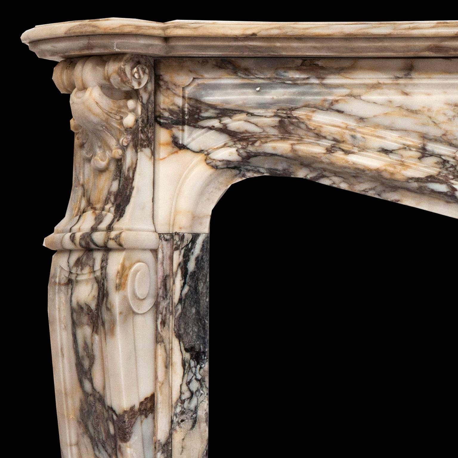 Beautiful 19th century antique Louis XV fireplace mantel, made out of rare colorful Breche de Benou marble. 
This Parisian fireplace is decorated with foliage, scrolls and flowers and surmounted by a shell.
 