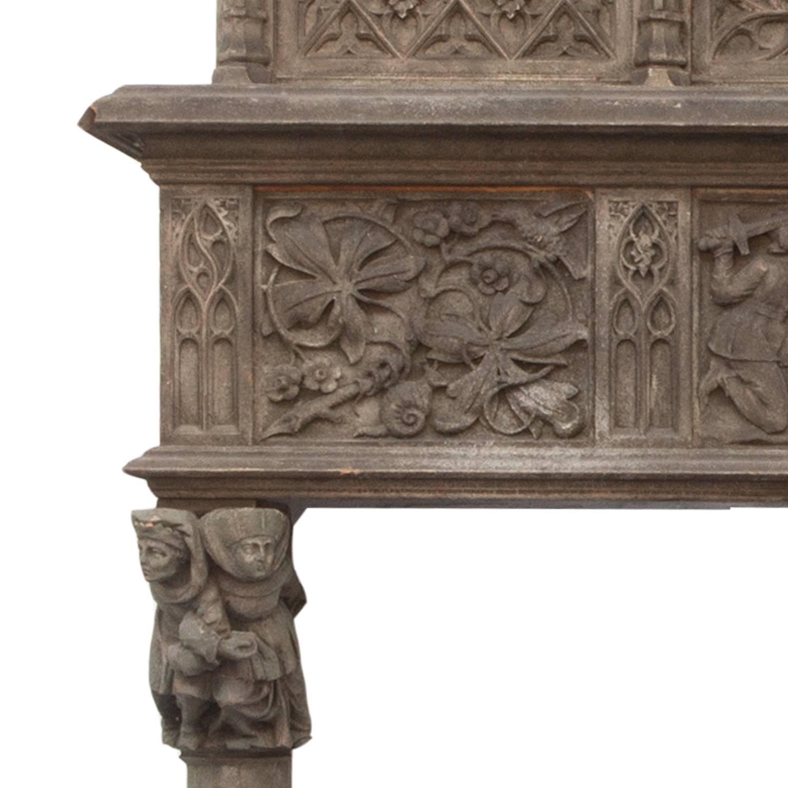 Extremely rare and beautifully hand-carved walnut English Victorian gothic fireplace surround and over-mantle-mantle. Originating from an Stately English Manor House in Somerset. Showing highly fine carved examples of figures and gestures in an aged