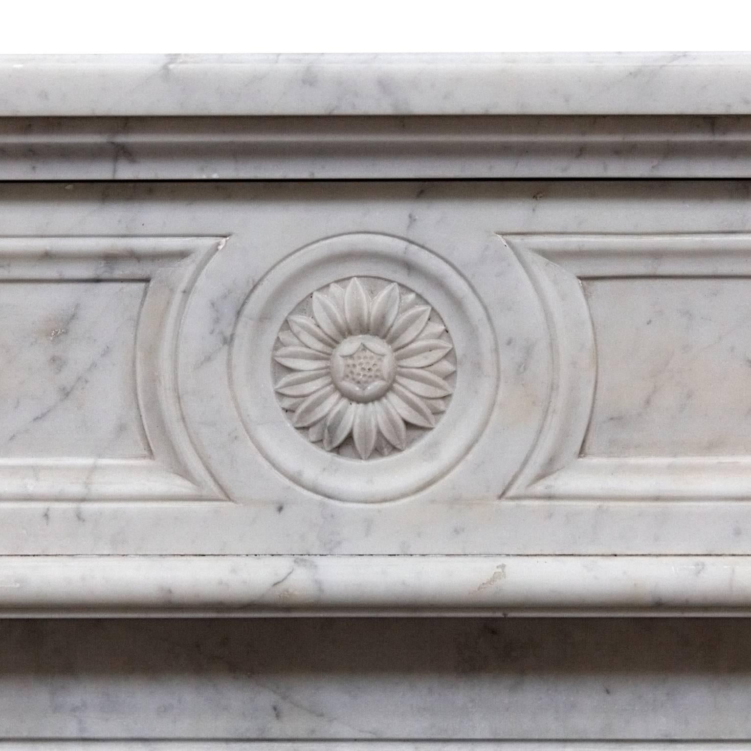 A fine 19th century Louis Philippe light Cararra marble honed fireplace mantelpiece.
Salvaged from a French Chateau near Paris. 
With finely hand-carved details above each jamb, a centre sunflower and recessed panels to the frieze and jambs