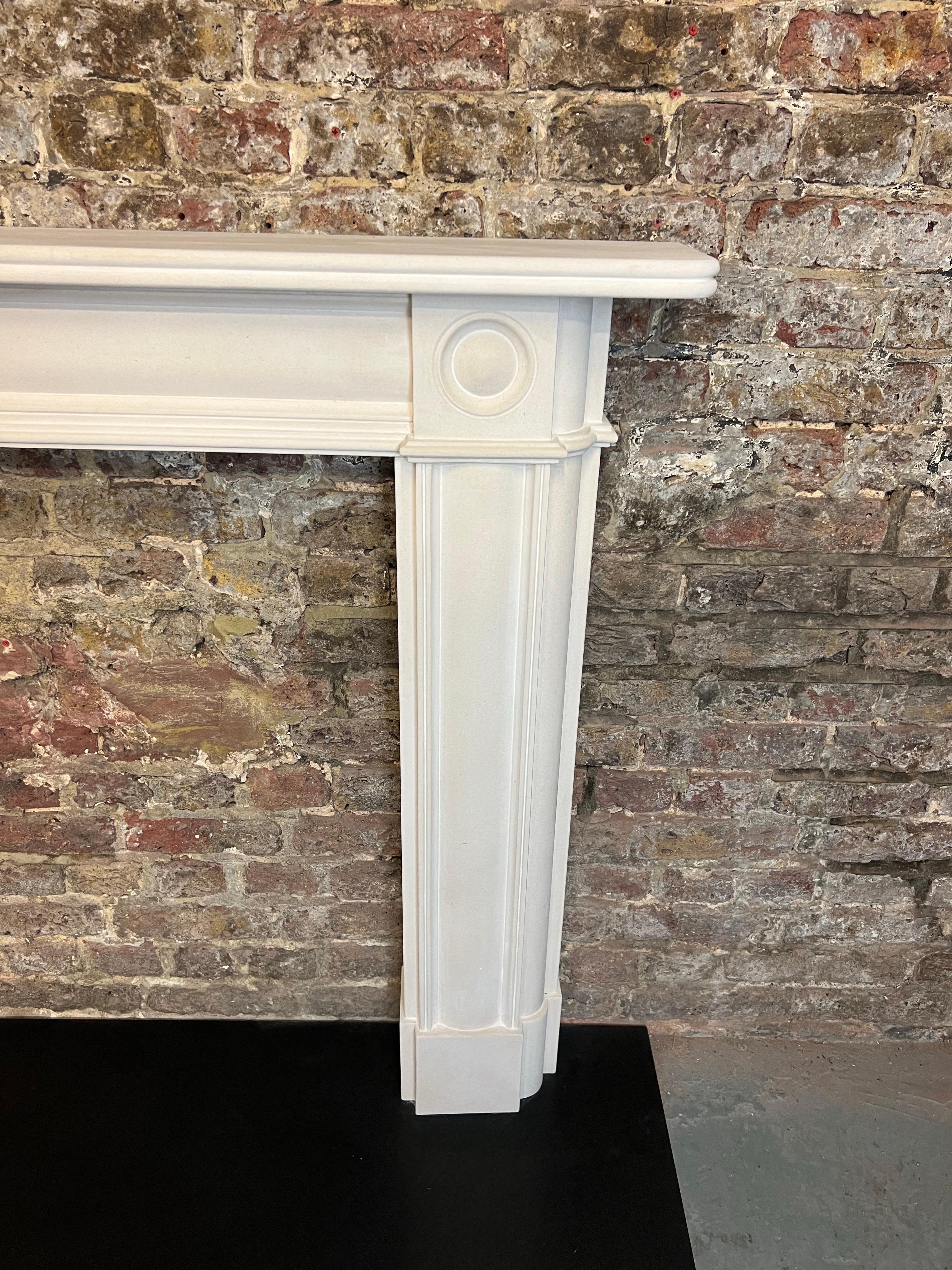 20th Century Bullseye Limestone Fireplace Mantlepiece.
This Vintage (Dated Circa 1990) Hand Carved Limestone Surround, English Made, Recently Salvaged From A London Town House.
Typical Georgian & Regency Design With Demi Lune Raised Panels On Its