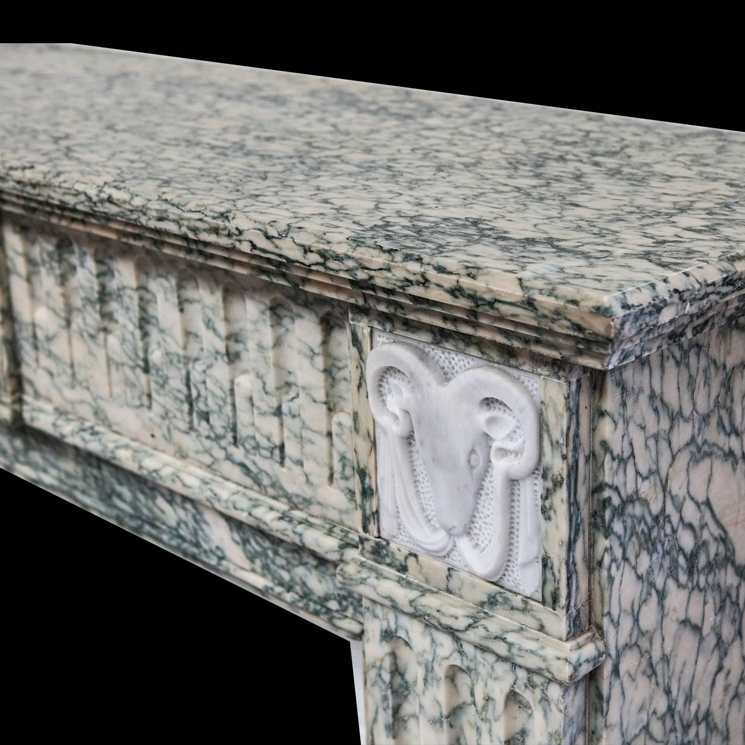Neoclassical Louis XVI French marble fireplace mantel. 
hand-carved from a rare light Campan vert marble, with a statuary white marble tablet showing a detailed flower basket and a pair of carved ram's heads sitting above each fluted jamb.

Shelf