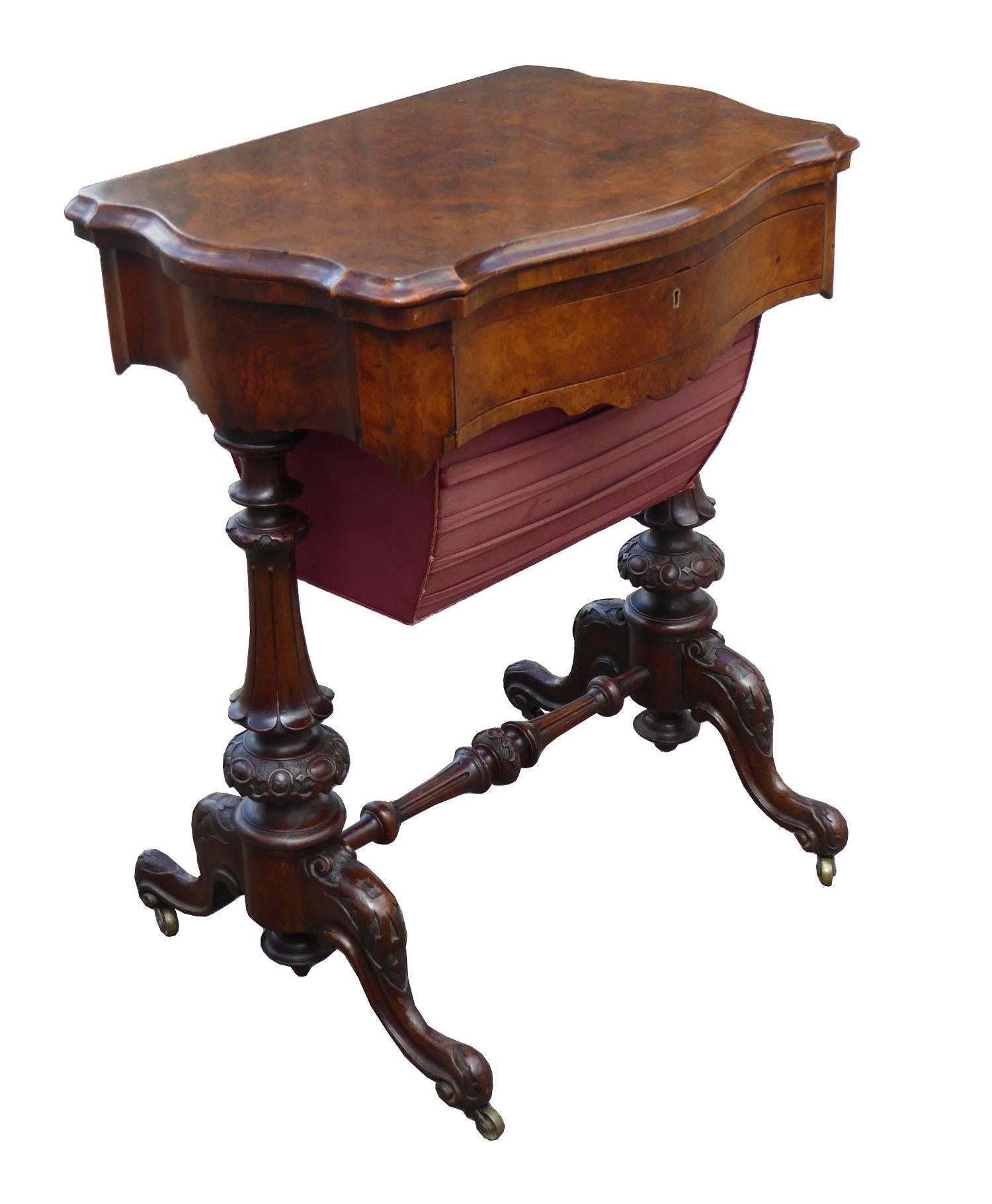 For sale is a good quality Victorian burr walnut work table or games table. The top of the table swivels and folds over to reveal a board for chess and for back gammon. Below this is a fitted drawer, above a pull-out basket. The table has ornately