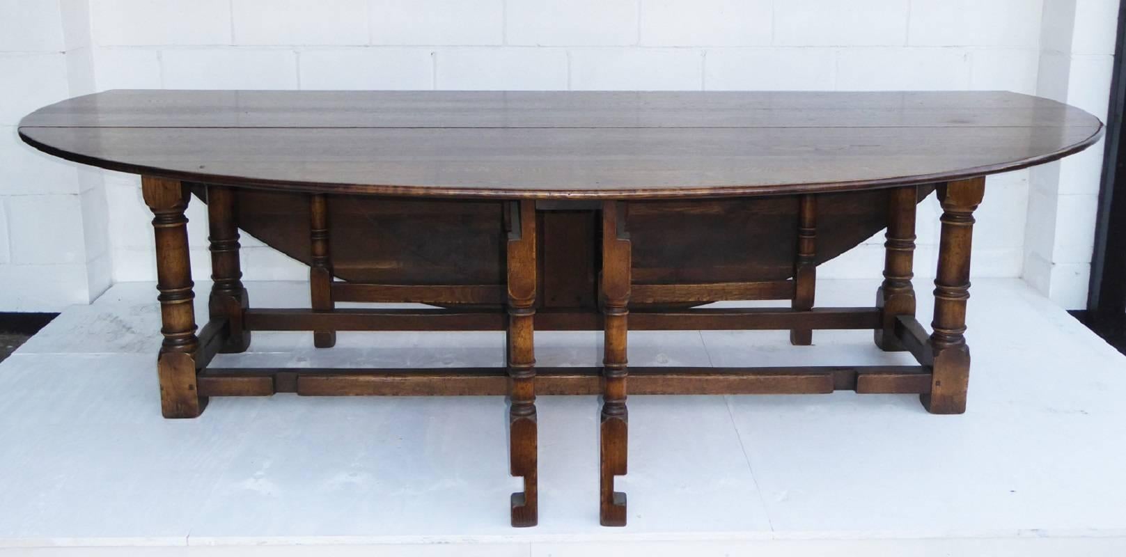 For sale is a good quality solid oak wakes table. The table has two drop leaves, one on either side, which are supported by a gated base. When the table is open, it is oval in shape and stands on gun barrel legs. This piece is in very good condition