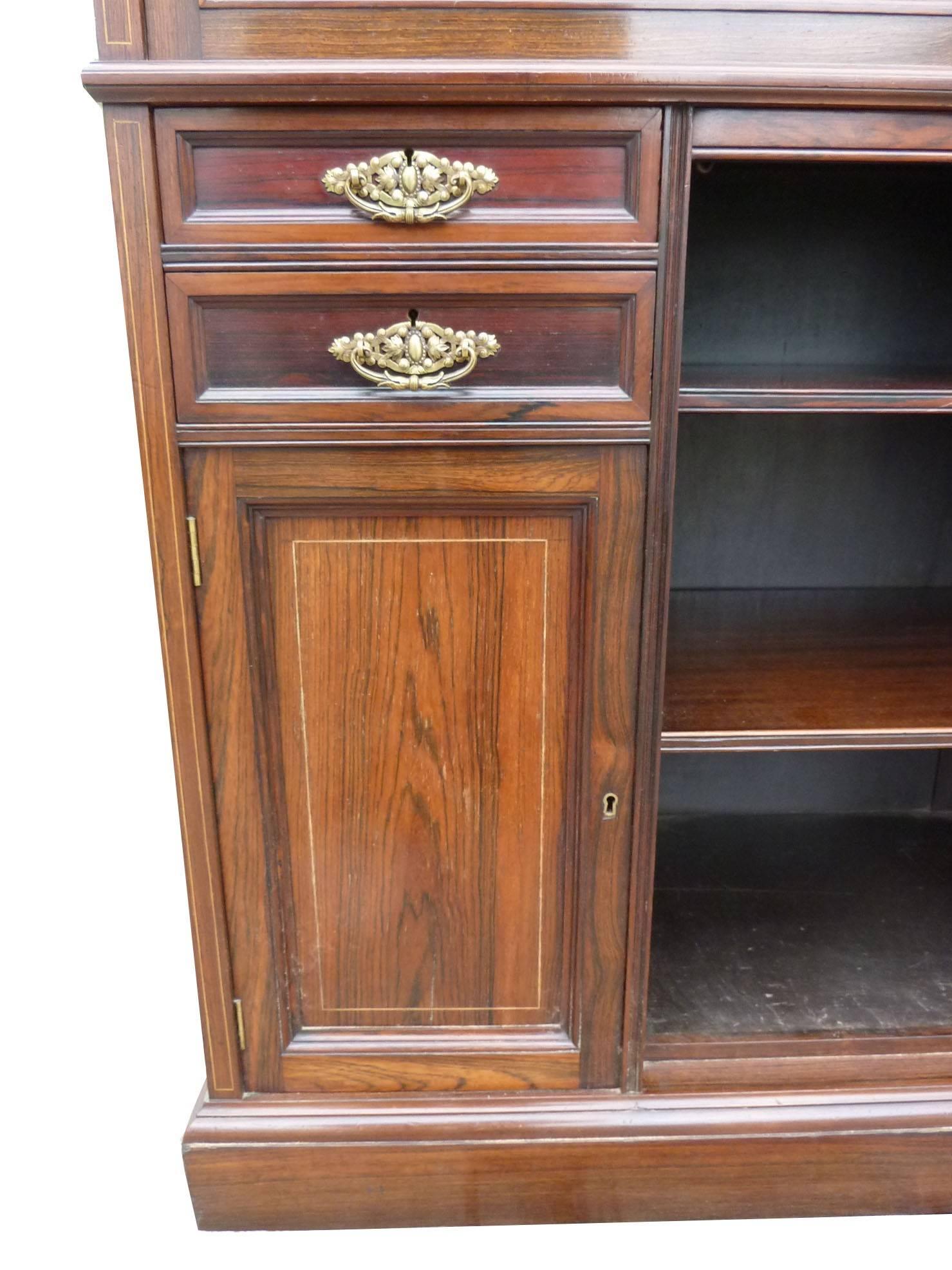 For sale is a very good quality Edwardian rosewood and inlaid chiffonier. The upstand with a mirror, supported by two beautifully turned columns above profusely inlaid drawers, with two further cabinets below and shelf space to the centre. This