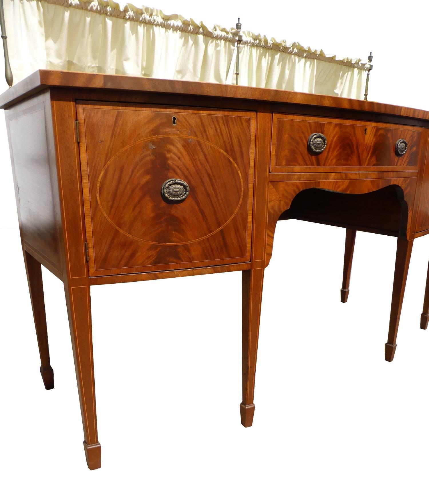 For sale is an Edwardian Regency style mahogany inlaid sideboard with a gallery back. The top of the sideboard has satinwood banding, above a long drawer in the centre which is flanked by a cupboard on either side. This item stands on tapering legs