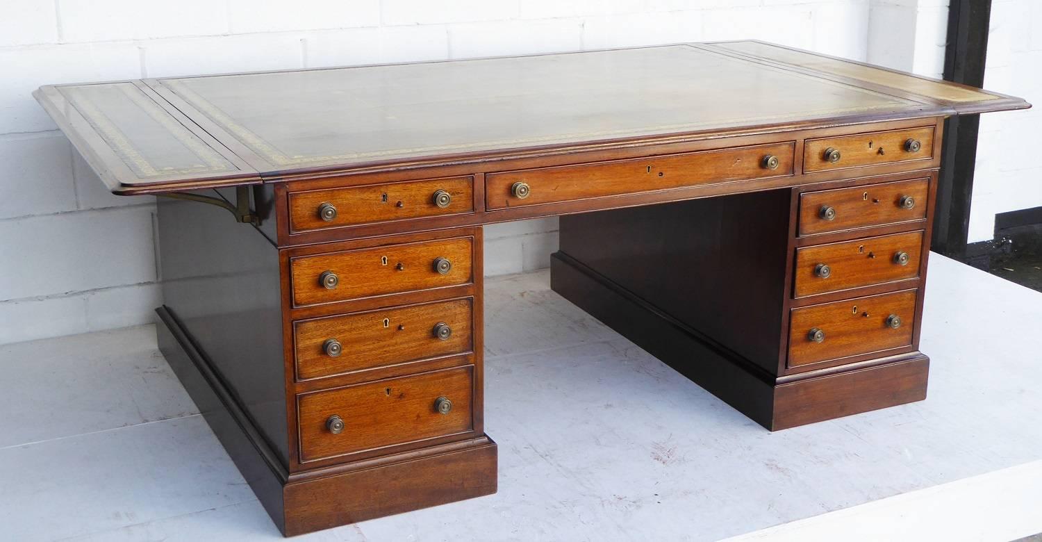 For sale is a fine quality Victorian, Georgian Style, mahogany partners desk. The top of the desk has its original leather insert, with a rising leaf on either side, extending the width of the top. Below this, are three drawers to the front, and