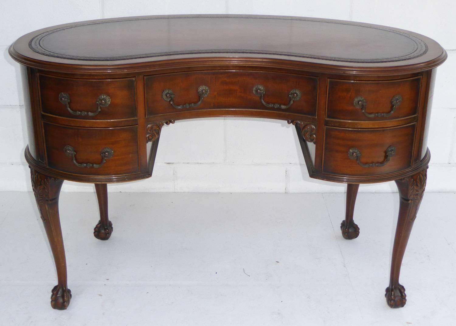For sale is a very good quality Edwardian Kidney shaped desk by Waring and Gillows. The top of the desk has a tan leather hyde insert, with decorative blind and gold tooling. The desk has five drawers each with ornate brass handles, to the top of