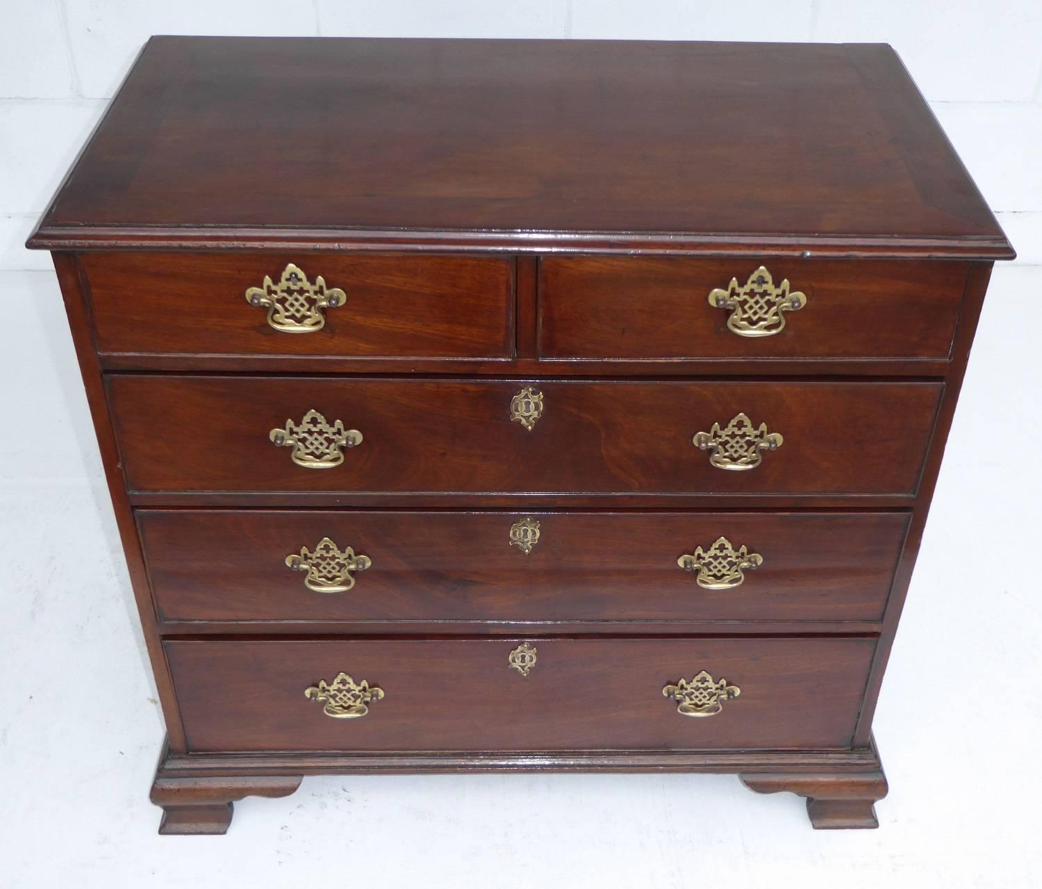For sale is a good quality George III mahogany chest of drawers of small proportions. The chest has two short drawers, over three long drawers. Each having ornate brass handles and the long drawers with intricate brass escutcheons. The chest stands