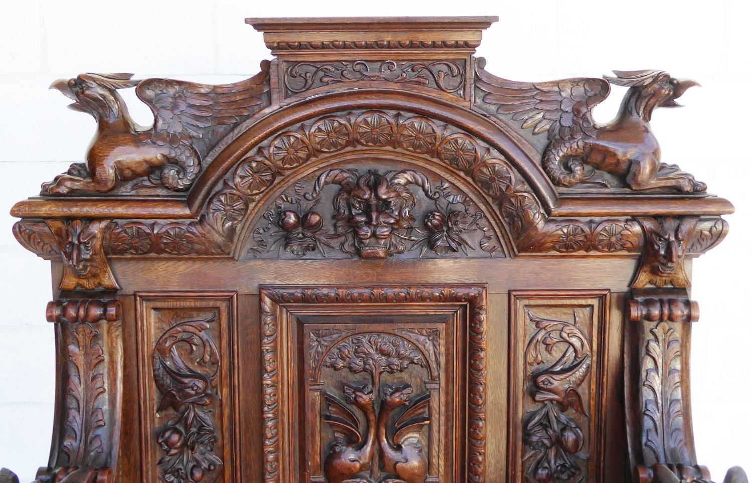 For sale is an extremely high quality carved bench. The top of the bench has two ornately carved griffins, one on either side. Between the griffins is an intricately carved mask with fruit on either side. The arms of the bench are heavily carved