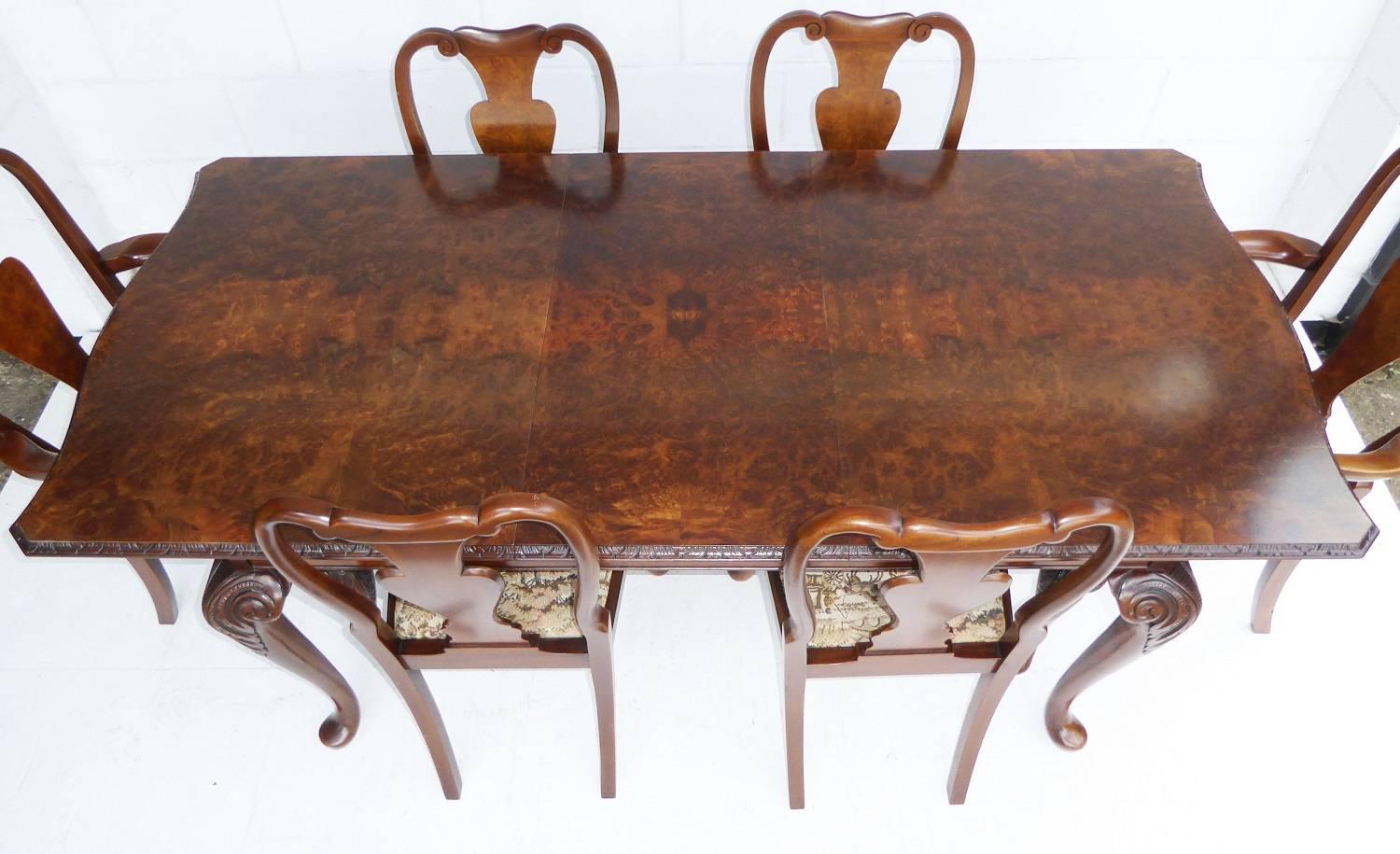 For sale is a burr walnut dining suite comprising burr walnut extending table, six burr walnut dining chairs, including two carvers, as well as a Burr Walnut Sideboard. Each chair has a double arched top with a vase shaped back, standing on cabriol
