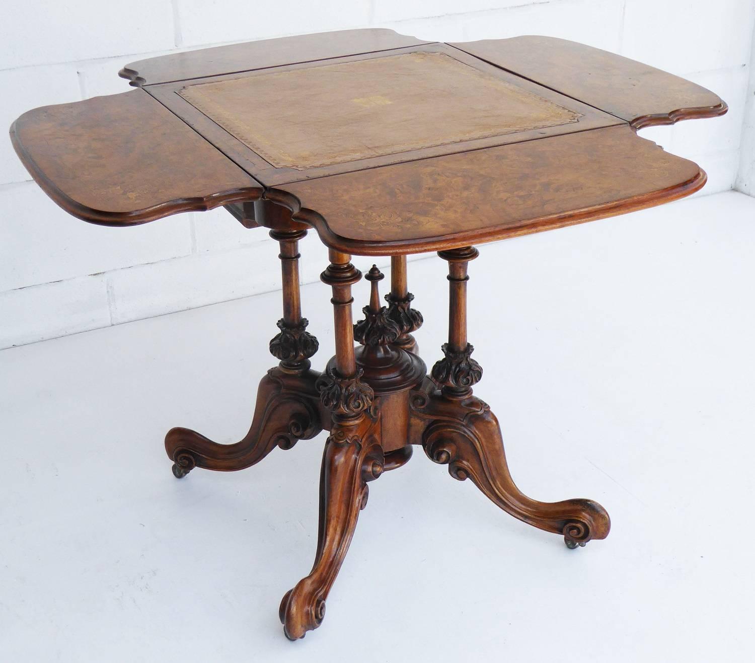 For sale is a fine quality Mid-Victorian burr walnut games table. The top of the table has a hazel colored leather, with decorative gold tooling and a centre motif. On each side of the table is a drop down flap, each nicely inlaid with floral