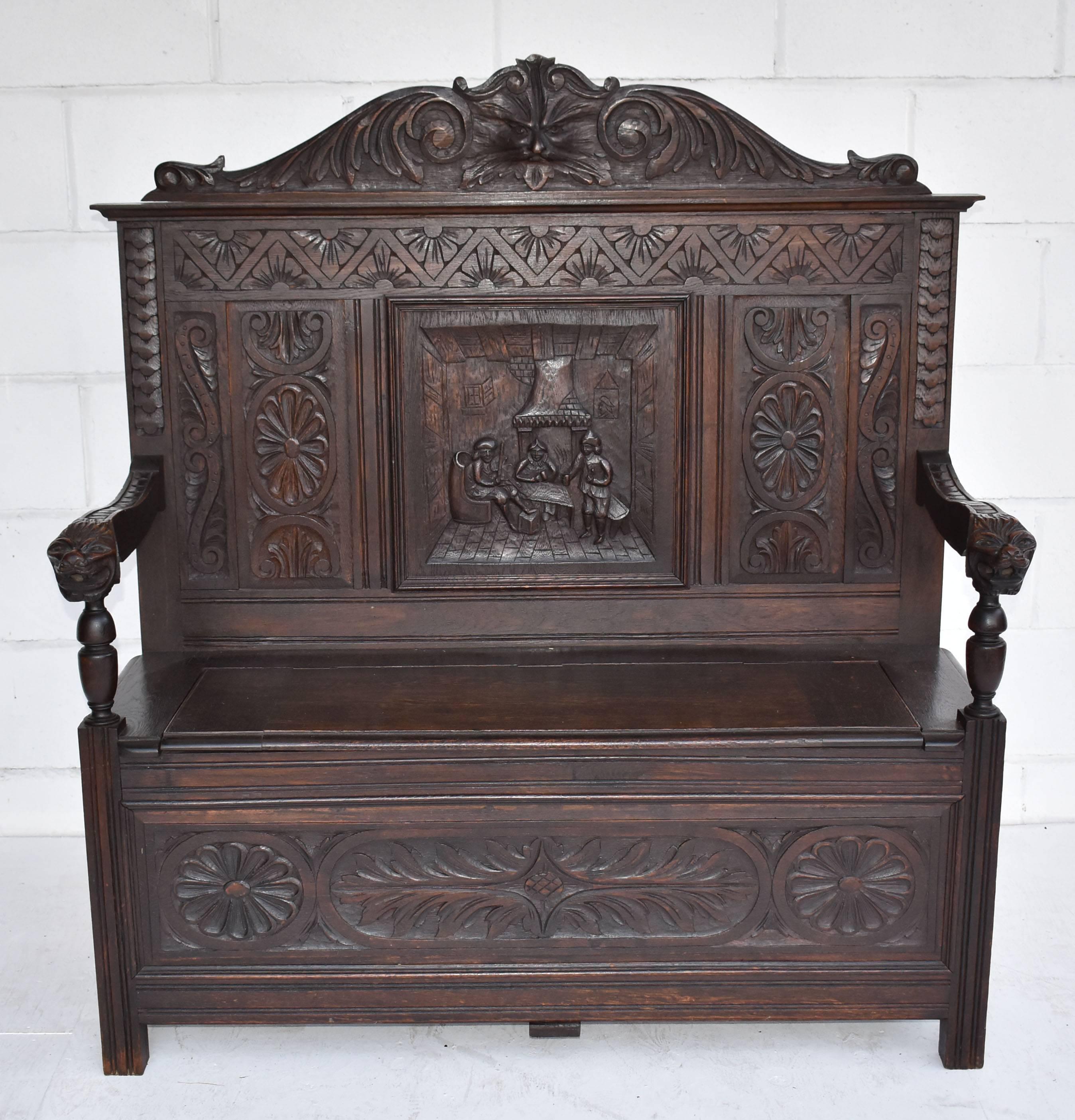 For sale is a good quality Victorian solid oak carved monk’s bench. The bench has an ornate pediment to the back with a carved mask, above three carved panels, the centre of which depicts a pub scene. Below this the seat has a rising lid, opening to