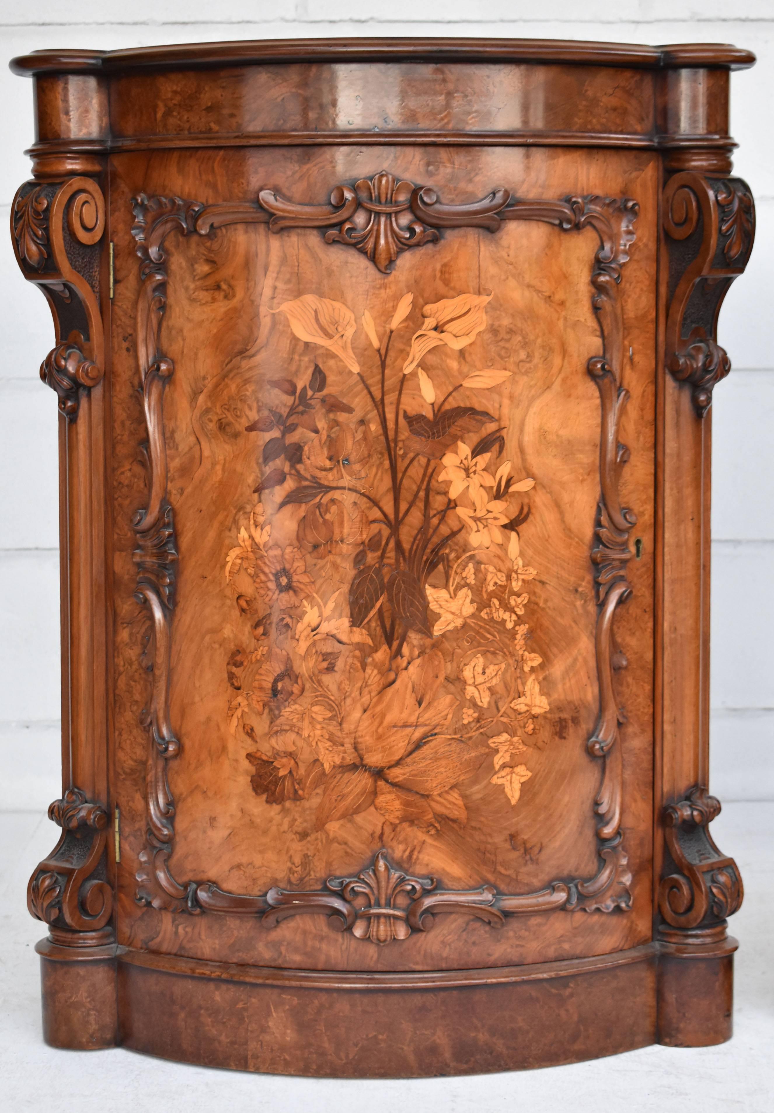 For sale is a fine quality pair of burr walnut corner cupboards, inlaid with specimen wood floral marquetry, with scroll carved mounts. Each cupboard is in very good condition. Both cupboards both open to reveal two shelves.

Measures: Width