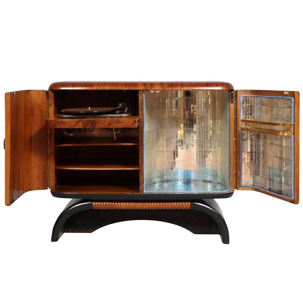 

Description: cabinet bar, the 1930s of the 20th century burr walnut and walnut flame applied folder. Two doors with brass handles Chippendale. Right Inside lined with mirrors, glass top turquoise. Interior light. And an internal shelf on the door.